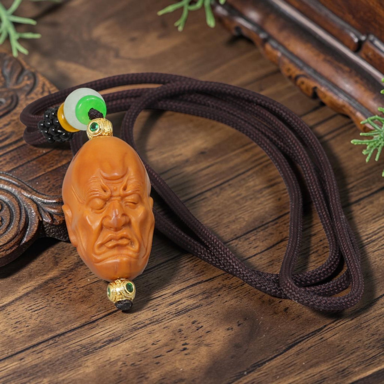 Chinese Olive Nut Pendant - Somber Closed-Eye Arhat Luohan Carving, 21YJ: Crafted from solid natural olive nut kernel, this wearable pendant displays precise hand-carved detailing of a somber closed-eye Arhat (Luohan) head marked by deep facial wrinkles, a classic icon with