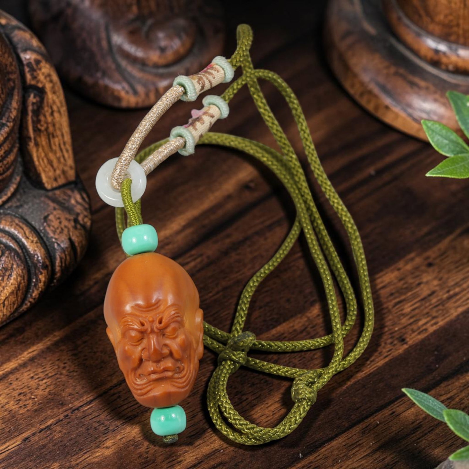 Chinese Olive Nut Pendant - Fierce Arhat Luohan Head Carving, 18AT: Formed from solid natural olive nut kernel, this wearable pendant displays finely hand-carved detail of a fierce-faced Arhat (Luohan) head with deeply wrinkled facial features, a standard motif within