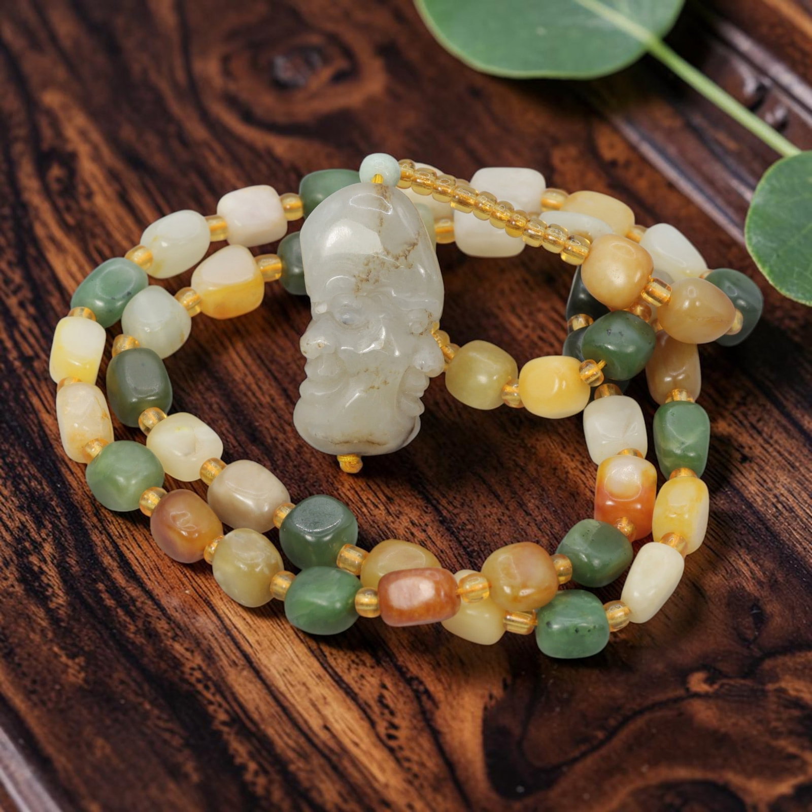 Natural Xinjiang Hetian Jade Necklace - Luohan Head Pendant, 73YJ: This necklace features a detailed natural Xinjiang Hetian jade luohan head pendant paired with matching multi-tonal Hetian jade pebble beads, accented with translucent yellow spacer beads. The pendant