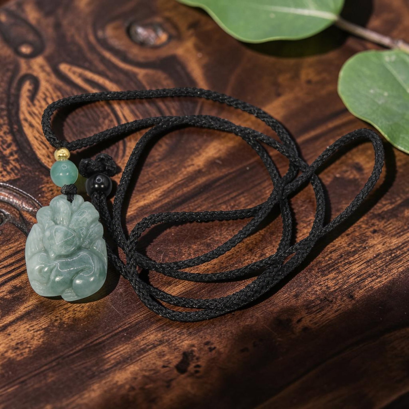 Natural Chinese Jade Nine-Tailed Fox Pendant with Adjustable Cord Necklace, 83YJ: This delicate necklace features a hand-carved natural Chinese jade nine-tailed fox pendant, paired with a black braided cord. The pendant is crafted from soft, pale greenish-blue jade, depicting a sty
