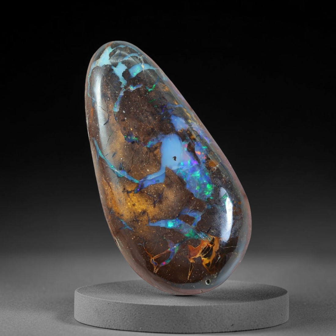 30.00ct Natural Australian Queensland Matrix Boulder Opal Cabochon, 76AT: Hand polished elongated freeform teardrop cabochon mined from Queensland boulder opal matrix, featuring dark ironstone base interwoven with vivid sky-blue opal pools, streaks of electric green iridesc