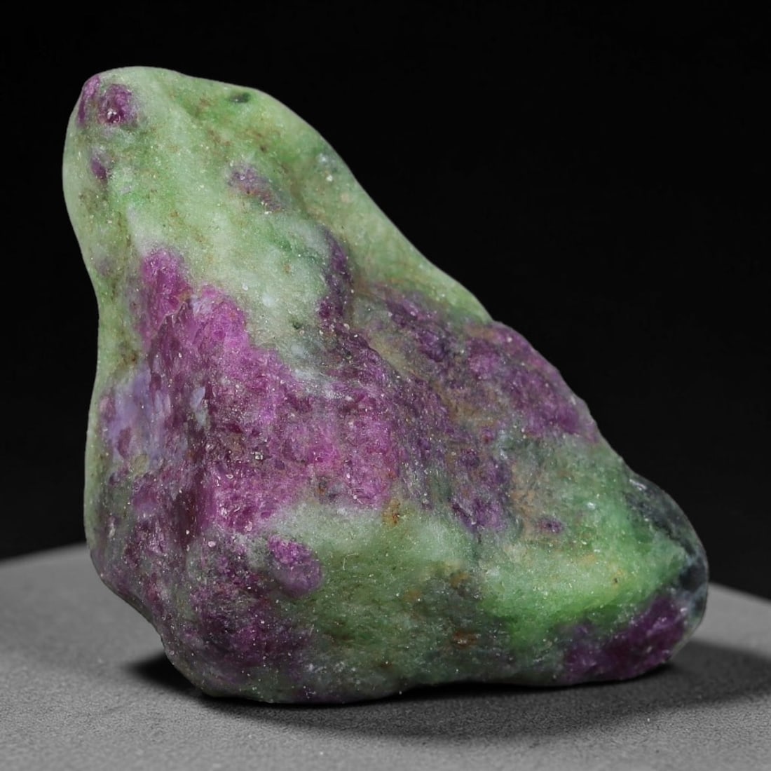 73ct Natural Tanzanian Ruby Zoisite Raw Rough Specimen Mineral Stone, 24FC: This unpolished mineral rough is natural ruby zoisite sourced from Tanzania, exhibiting distinct banded mineral segregation of vibrant green zoisite, magenta ruby crystals, and dark hornblende inclusi