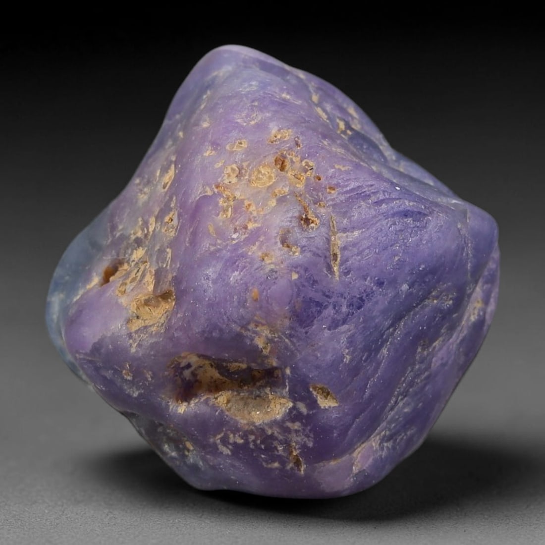 61.42ct Natural Unheated Sri Lankan Purplish Blue Sapphire Rough, 70FC: This natural corundum rough is an unheated purplish blue sapphire sourced from Sri Lankan alluvial gem deposits, featuring an irregular natural native form with residual pale yellow-brown mineral matr