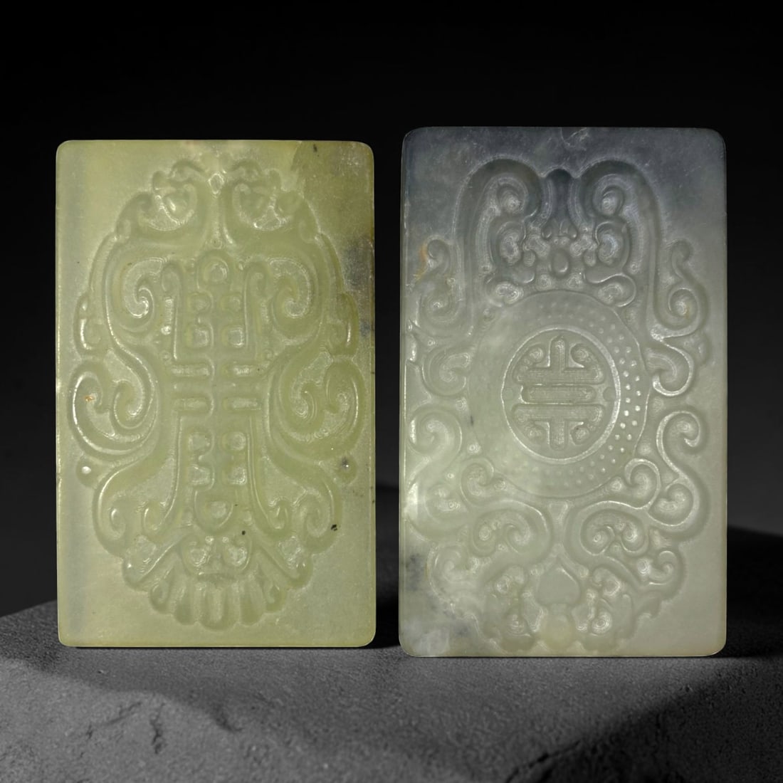 Lot of 2 Chinese Hetian Nephrite Jade Plaques, 59AG: The lot comprises two rectangular nephrite jade plaques. The first plaque is carved from pale celadon nephrite with minor natural inclusions and faint surface marks. The second is crafted from greyish