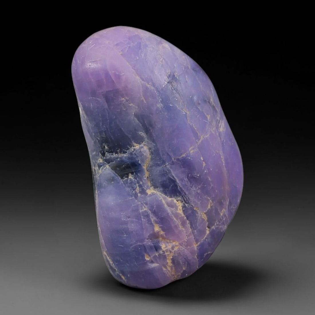 35.11ct Natural Unheated Sri Lankan Purplish Blue Sapphire Rough, 63FC: This natural corundum rough is an unheated purplish blue sapphire sourced from Sri Lankan alluvial gem deposits, featuring an irregular natural native form with residual pale yellow-brown mineral matr