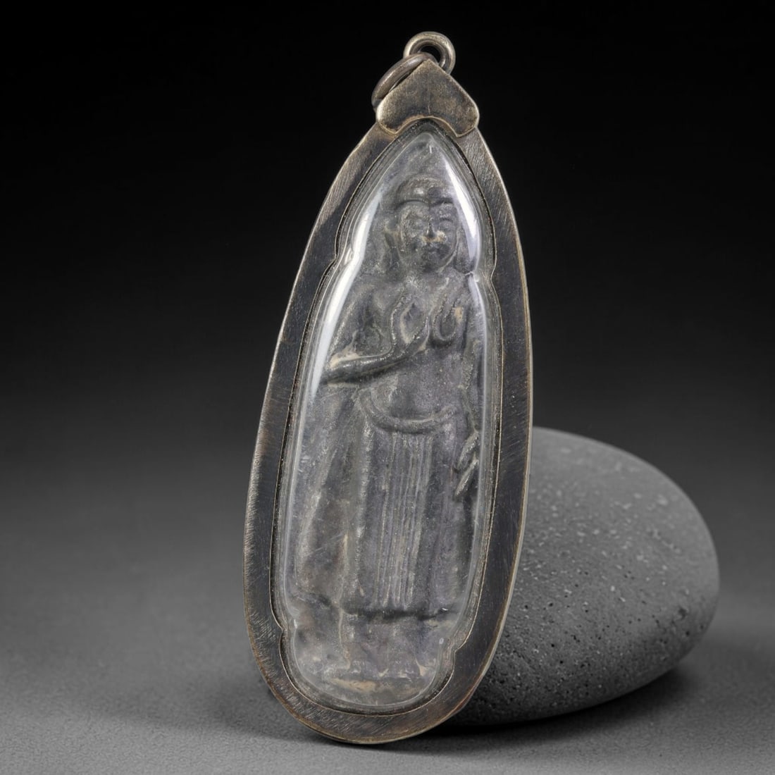 Vintage Thai Amulet Pendant - Teardrop Metal Buddha Talisman with Aluminium Casing, 95AA: Vintage elongated teardrop-shaped Thai amulet measuring 7cm x 2.6cm, cast with embossed standing Buddha figure in traditional mudra robe detailing, featuring dark aged metallic patina across the sacre