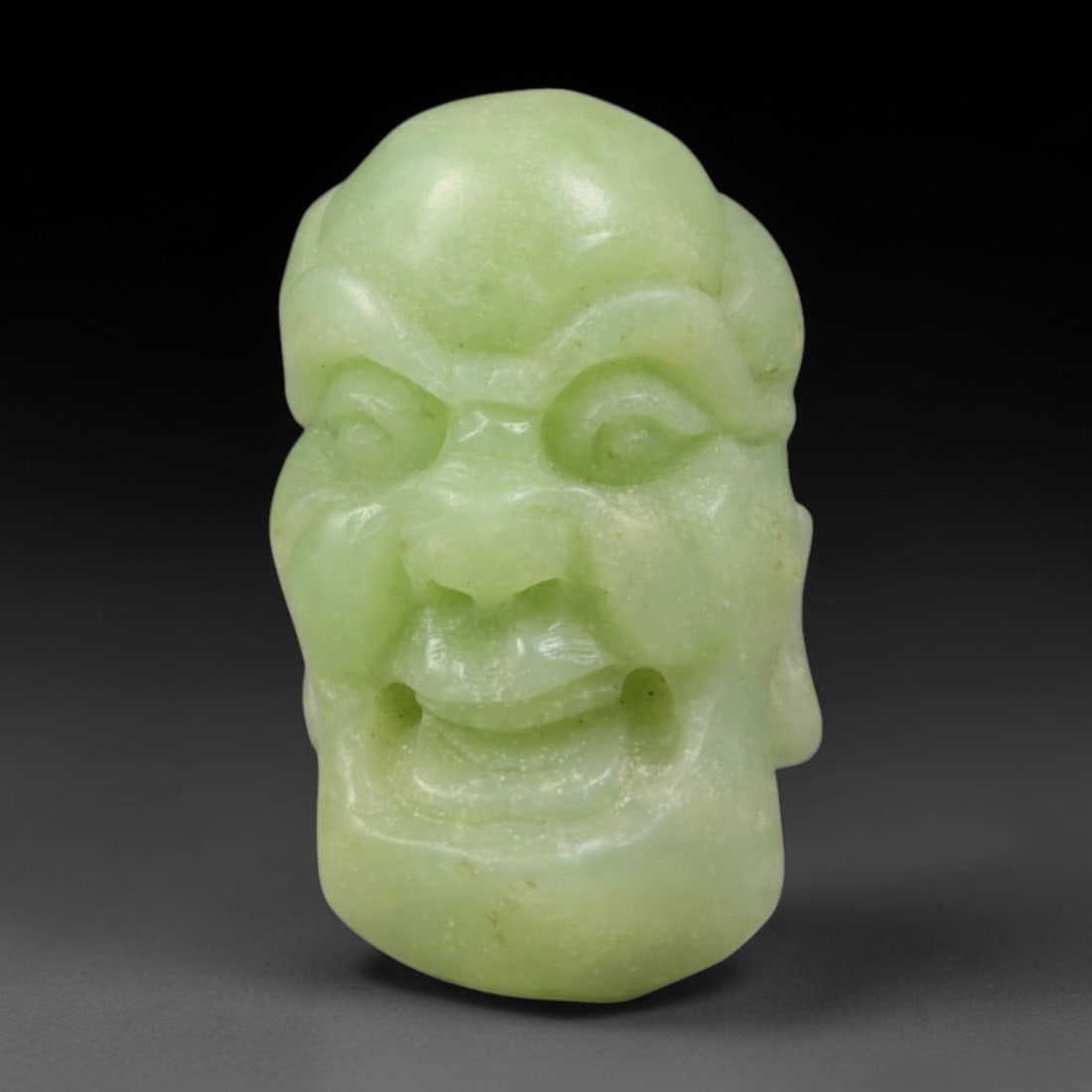 Natural Vintage Chinese Nephrite Jade Pale Light Green Laughing Arhat Head Carved Face Bead, 35AP: Hand-carved vintage Chinese strung bead crafted from natural vintage Chinese nephrite jade, measuring 3cm x 1.8cm. This barrel-form bead is fully sculpted into a joyful laughing Buddhist Arhat facial 