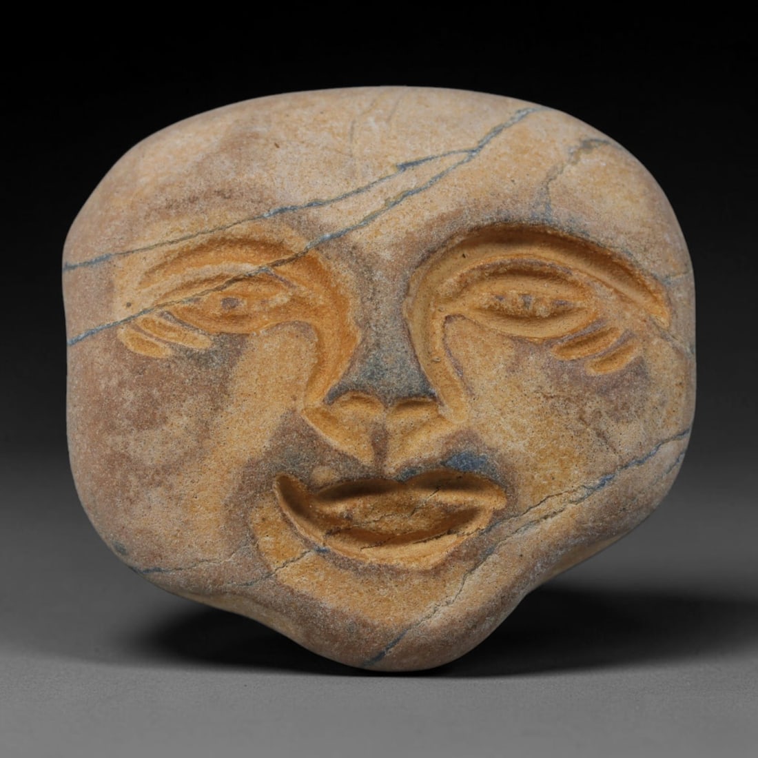 Ancient Medieval Mediterranean Hand Carved Stone Maskette Amulet, 63AP: Miniature wearable sacred talisman hand hewn from natural soft stone, originating from Medieval Mediterranean cultural craft traditions. Small carved stone amulets were widespread personal artifacts a