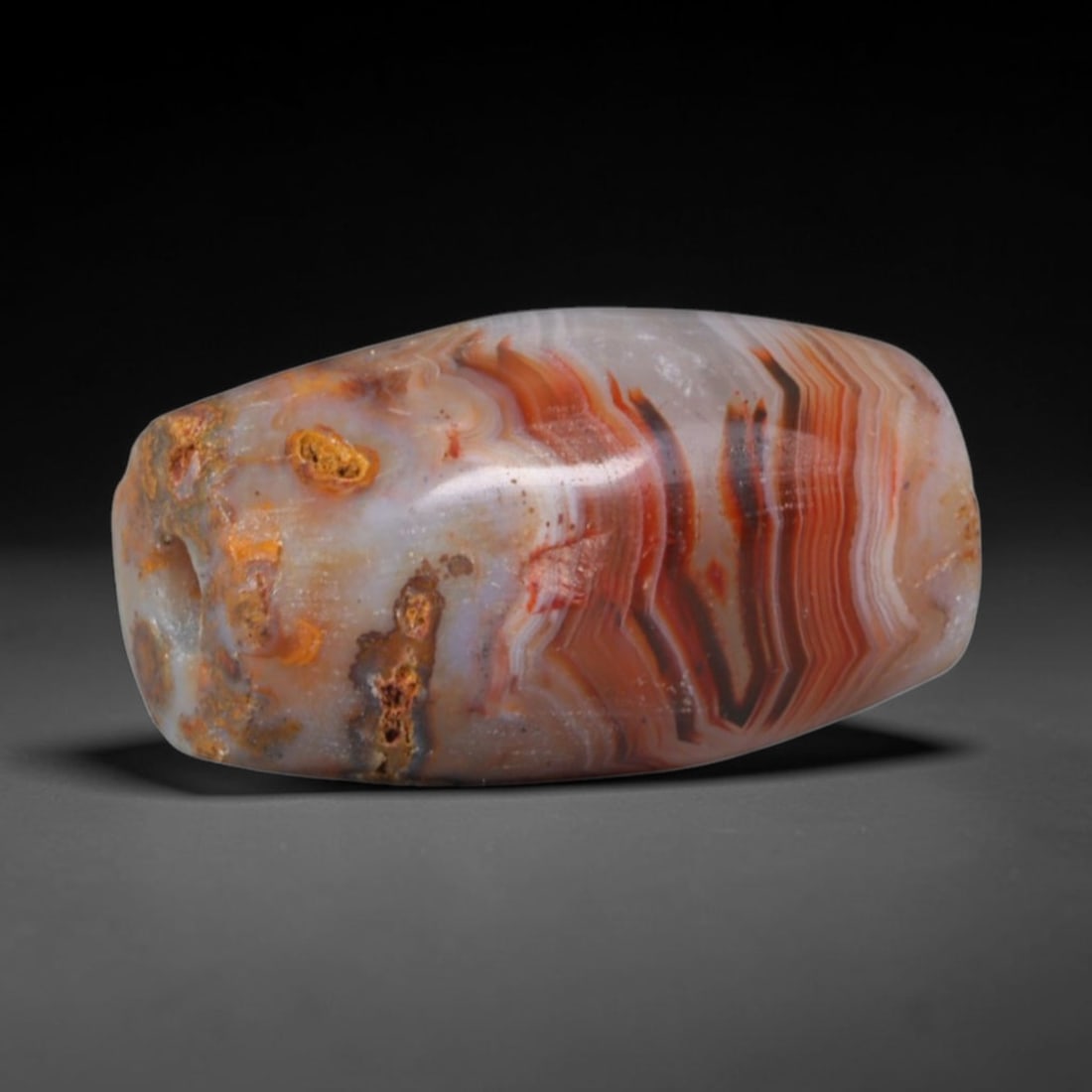 Ancient Gujarat Cambay Post-Harappan Bead Culture Banded Agate Barrel Bead (300 BCE-1000 CE), 19AD: This antique banded agate barrel bead originates from the Gujarat Cambay Post-Harappan Bead Culture, a sustained Western Indian workshop tradition centered at Khambhat that mass-produced elaborate ban