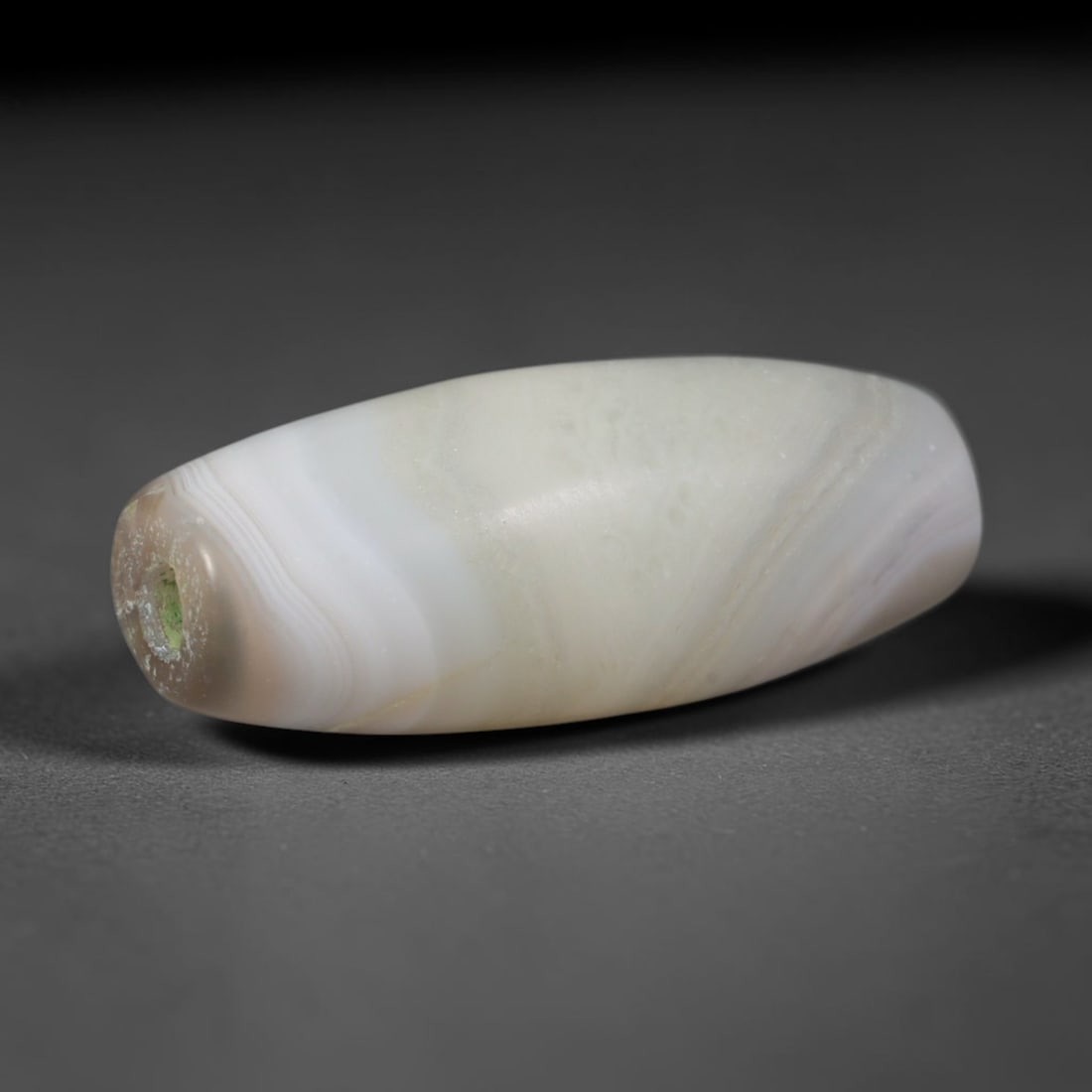 Ancient Shunga Dynasty Gradient Wavy Cream Banded Pale Agate Barrel Bead (185-72 BCE), 88AD: This elongated soft-toned banded agate barrel bead originates from India's Shunga Dynasty, a post-Mauryan South Asian civilization with refined agate carving traditions that crafted sacred protective 
