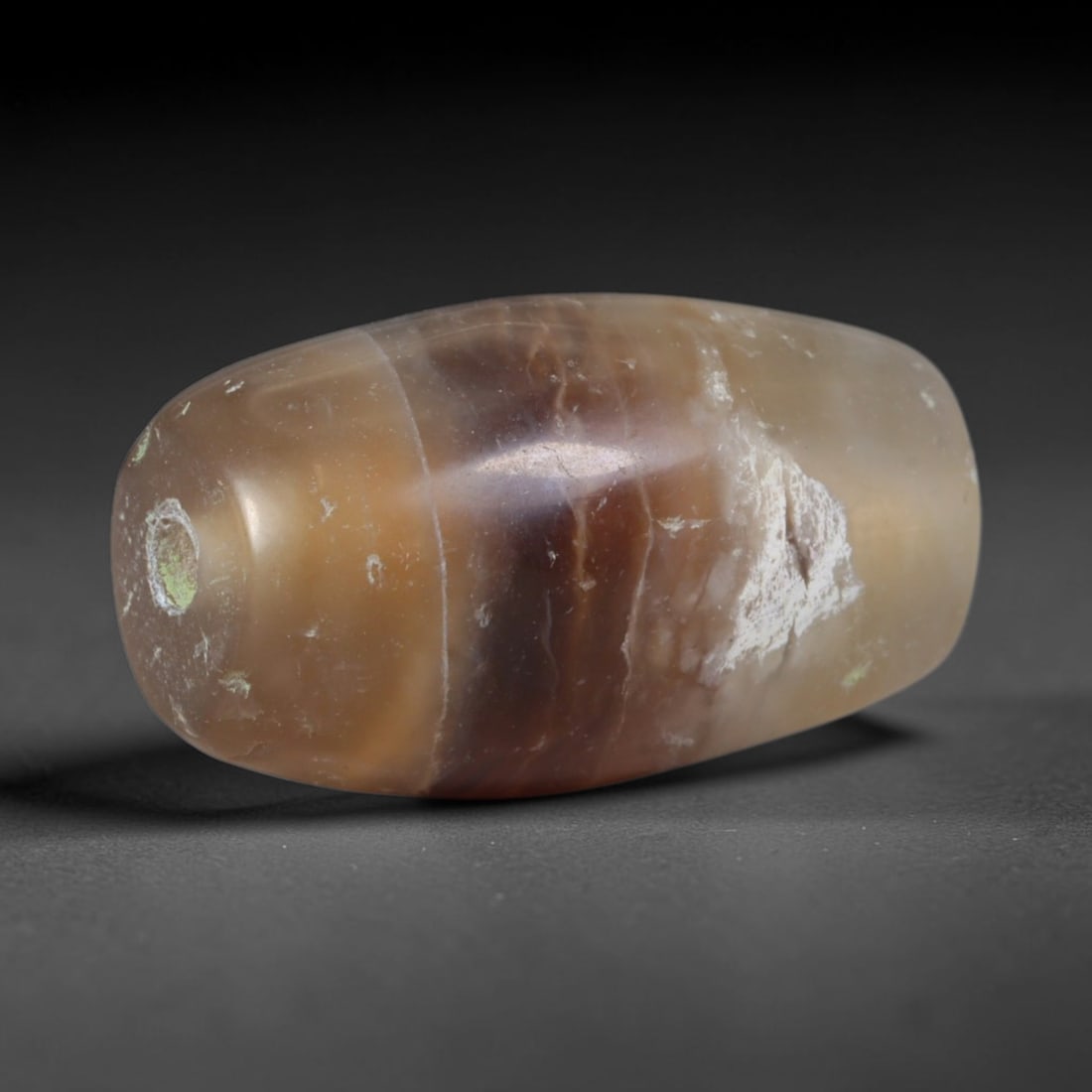 Ancient Parthian Persian Empire Honey Banded Agate Barrel Bead (247 BCE - 224 CE), 78AD: This antique warm-toned banded agate barrel bead originates from the Parthian Persian Empire, a dominant Silk Road power celebrated for agate lapidary workshops crafting protective talismanic beads tr