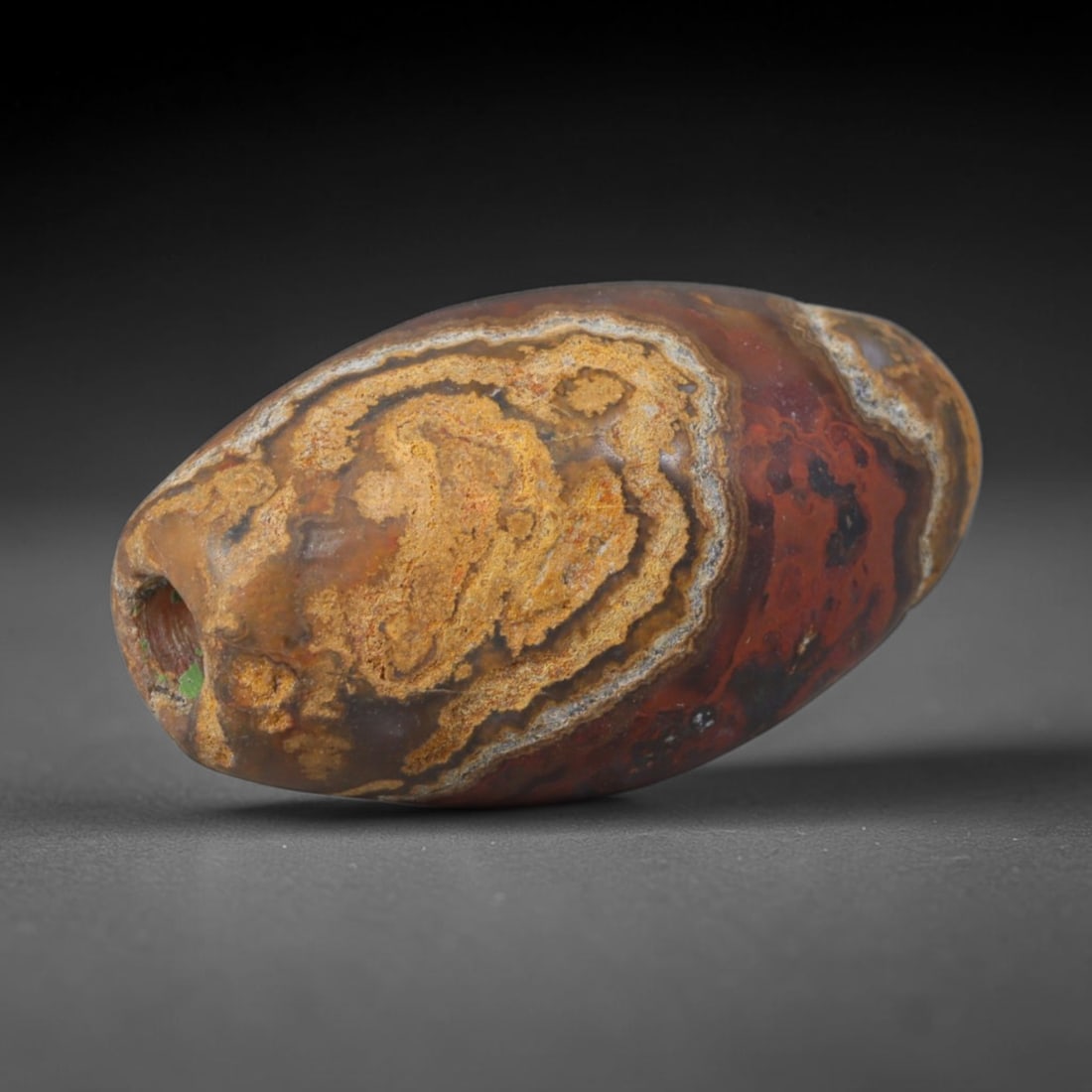 Ancient Warring States Earthy Ochre Banded Agate Barrel Bead (475-221 BCE), 77AD: This antique richly hued banded agate barrel bead originates from China's Warring States Period, an era of refined regional lapidary arts that produced symbolic stone ornaments for aristocratic wear, 