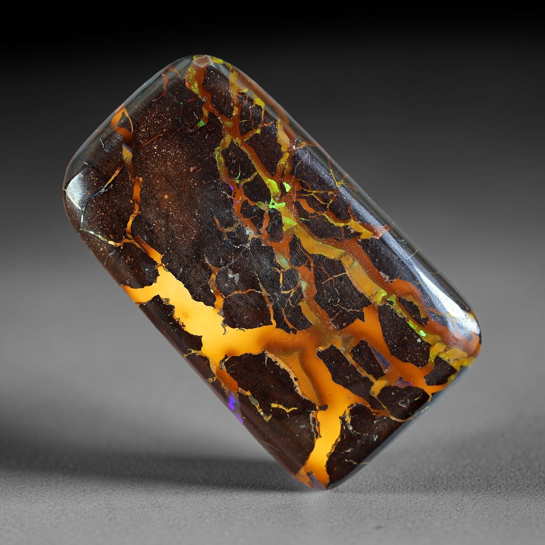 30.45ct Natural Australian Queensland Matrix Boulder Opal Cabochon, 7AV: Hand polished rounded rectangular cushion cabochon crafted from natural Queensland matrix boulder opal, featuring dense dark ironstone host rock intersected by broad luminous golden opal veins dotted 