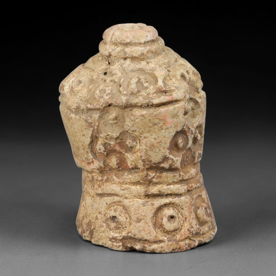 Ancient Medieval Mamluk Islamic Stone Bell Form Talisman (1250-1517 CE), 68AB: This pale weathered stone bell-shaped pendant originates from Mamluk Islamic craft, portable protective talismans covered in repeating circular decorative incised motifs across its domed upper body an