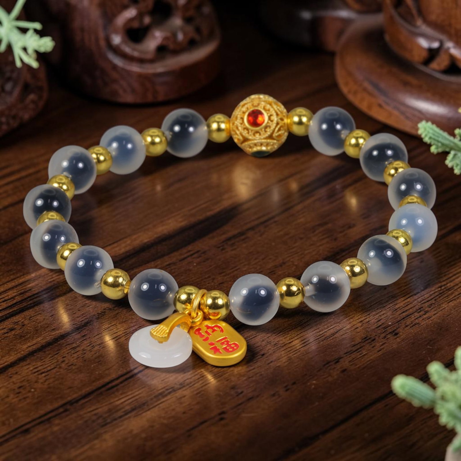 A Chinese Glass Beaded Bracelet - Frosted Grey Glass Gilded Charm Strand, 8AP: Hand-strung bracelet constructed with smooth 8mm frosted translucent grey glass round beads, separated by polished small gilded metal spacer beads. A central ornate filigree gilded focal bead set with