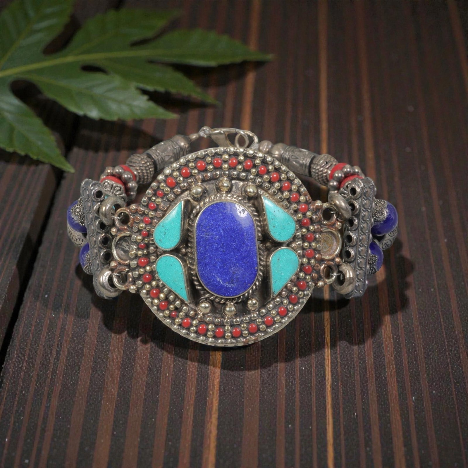 A Vintage Himalayan Silver-Plated Multi-Stone Inlay Bracelet, 5AH: A handcrafted vintage bracelet, measuring approximately 7 cm in width, showcasing traditional Himalayan jewelry design. The piece features a silver-plated metal base with a large central oval lapis la