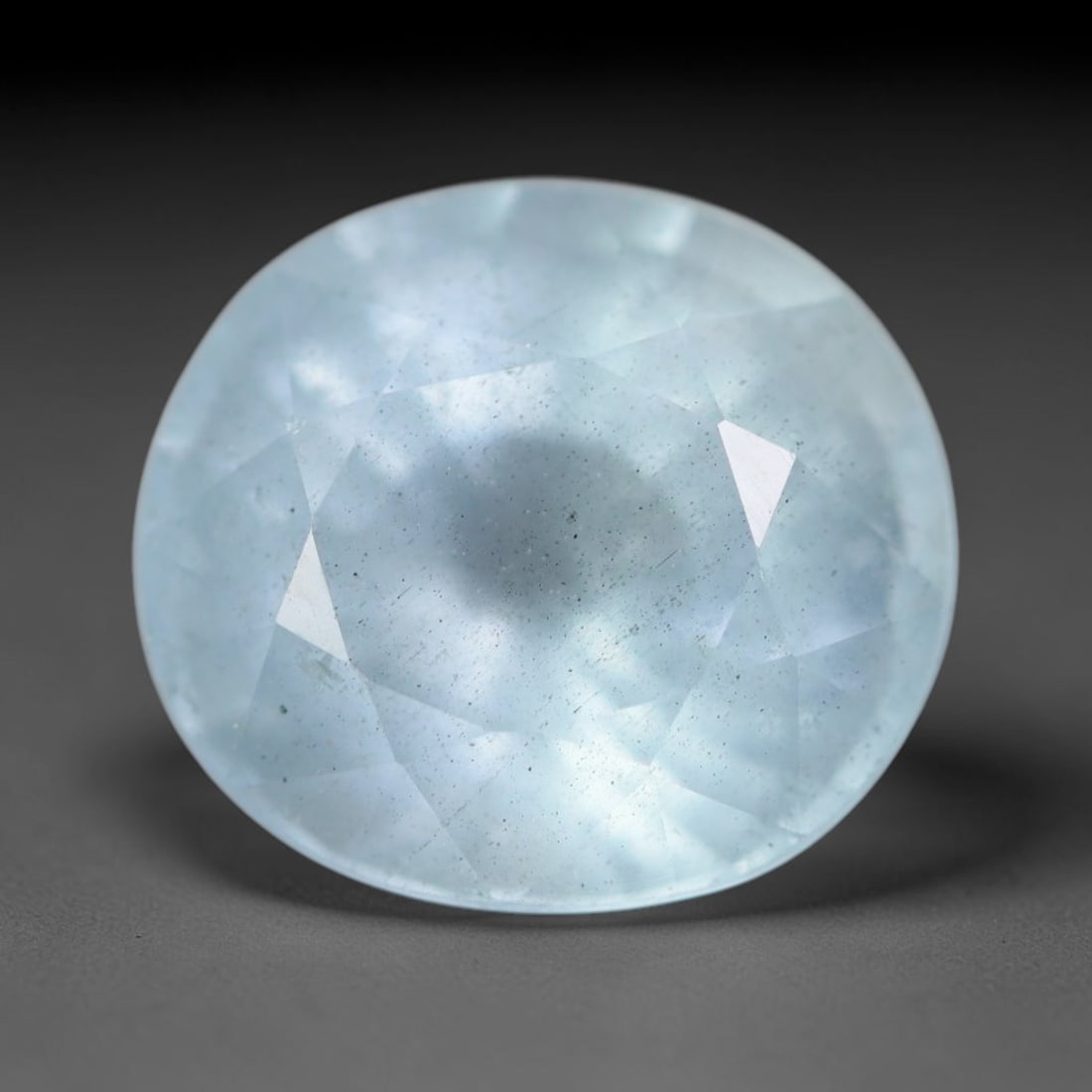 4.60 Carats Natural Brazilian Soft Sky Blue Aquamarine Loose Gemstone, 32AG: This serene sky blue aquamarine carries smooth icy pale blue saturation with gentle light refracting across its polished facets, measured at 11x10x7.5mm, its cool tranquil tone lends effortless elegan