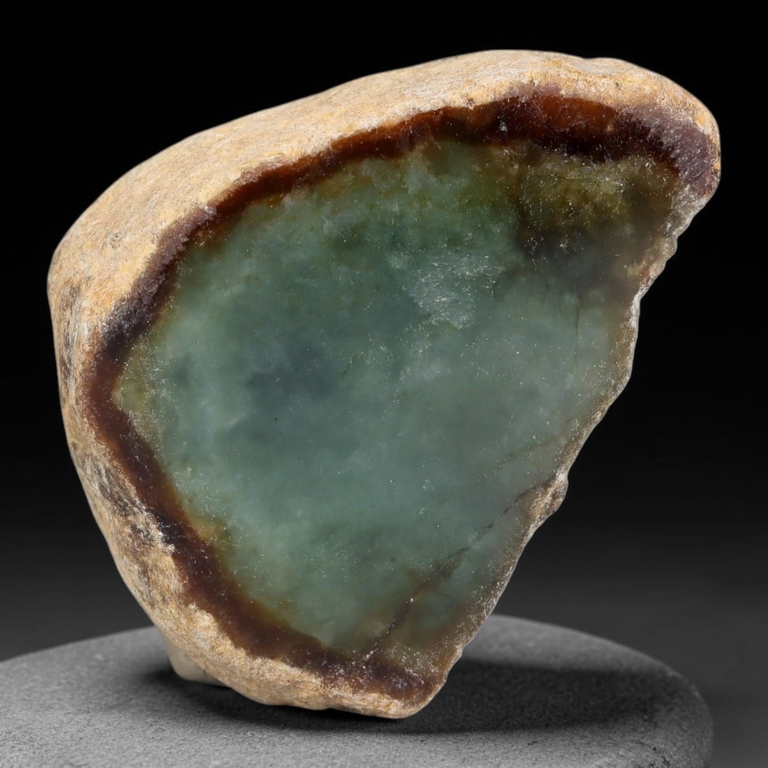180ct Natural Type A Burmese Red Skin Rim Icy Teal Jadeite Jade Sliced Rough, 10FA: This specimen is a small sliced rough pebble of untreated Type A Burmese jadeite, framed by a distinct rich reddish-brown oxidized skin rim along its polished cut face perimeter. The interior features