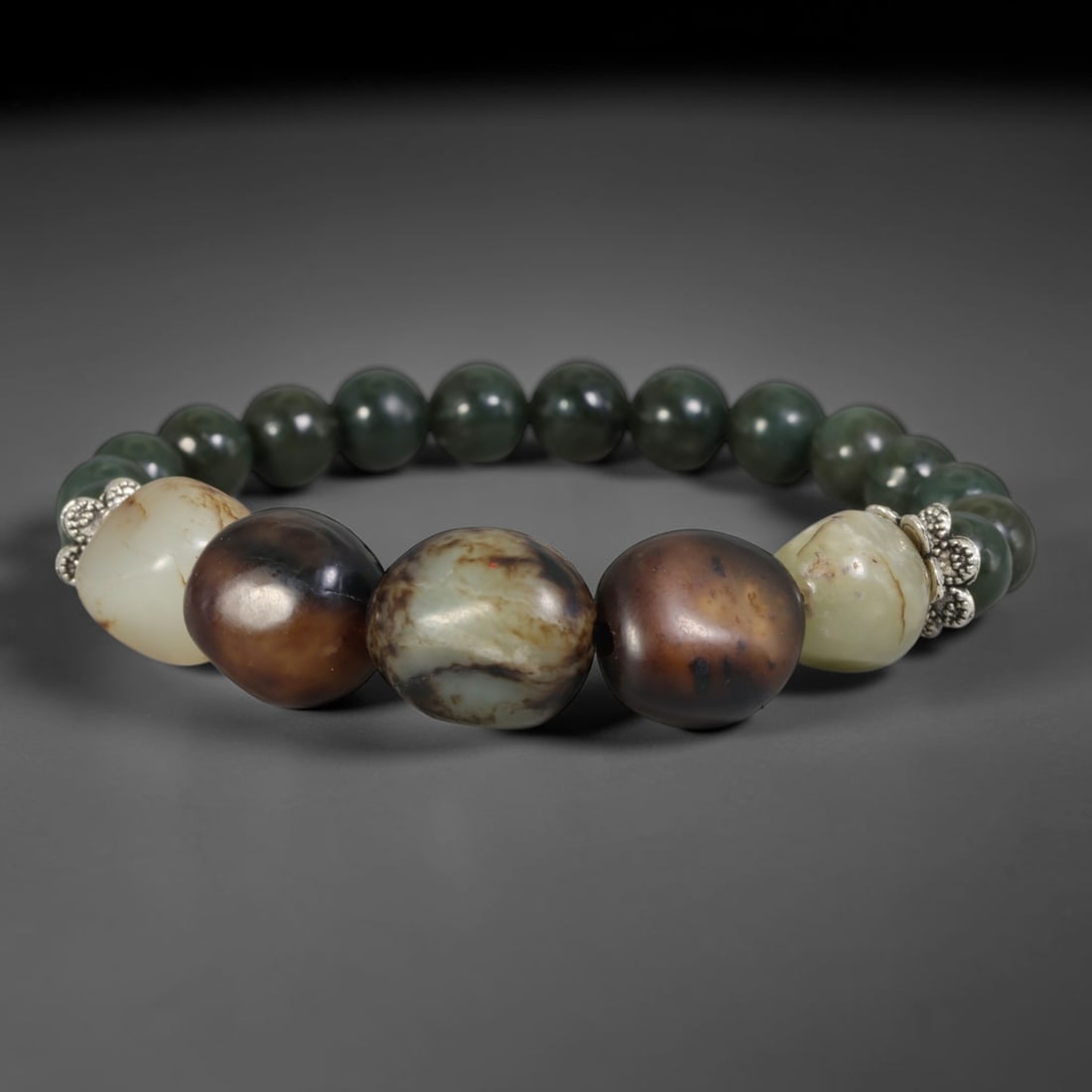 Mixed Natural Chinese Xinjiang Hetian Nephrite Jade Bracelet, 68AE: Hand-assembled Hetian nephrite bracelet featuring smooth uniform dark green spherical nephrite beads, paired with five central organic river pebble jade stones showcasing varied natural patina: pale c