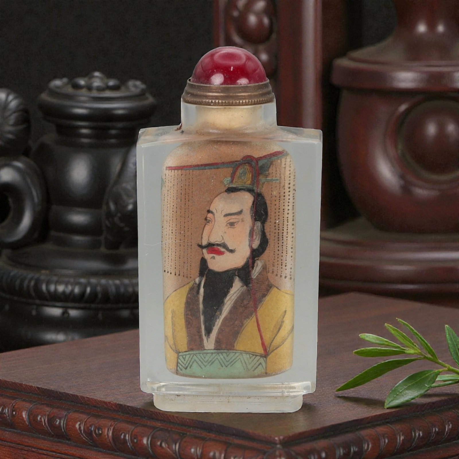 A Chinese Crystal Glass Snuff Bottle, 20th Century, 63FG: The snuff bottle is formed from clear crystal glass and of flattened rectangular form, rising from a narrow foot to a short cylindrical neck with a flat rim. One side is inside-painted with a frontal 