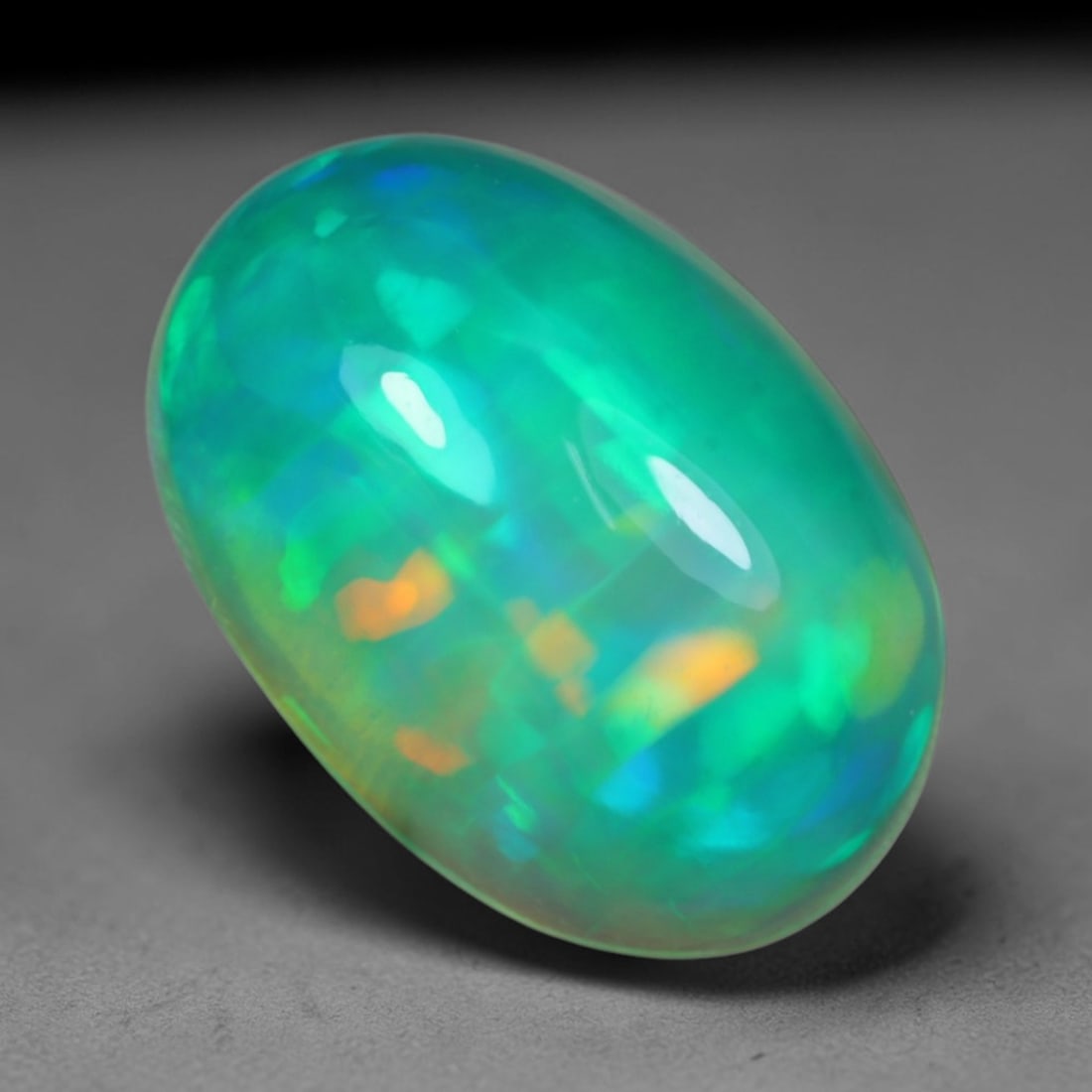 3.00 Carats Natural Ethiopian Welo Teal Blue Green Opal Cabochon Loose Gemstone, 59AG: This lustrous polished opal features a rich teal base filled with swirling patches of neon mint green and bright cerulean blue shifting play of color, measured at 12.7x8.7x5.3mm, its cool aquatic mult