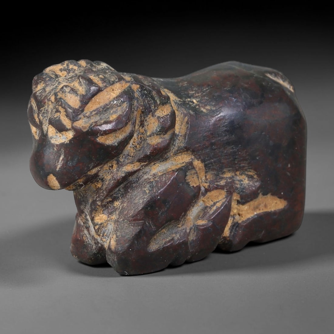 Ancient Achaemenid Persian Carved Stone Ram Amulet (550-330 BCE), 23AB: This dark mottled stone recumbent ram carving originates from Achaemenid Persian Empire, imperial craft animal talismans linked to Zoroastrian ritual and royal burial regalia. Deep hand-carved detaili