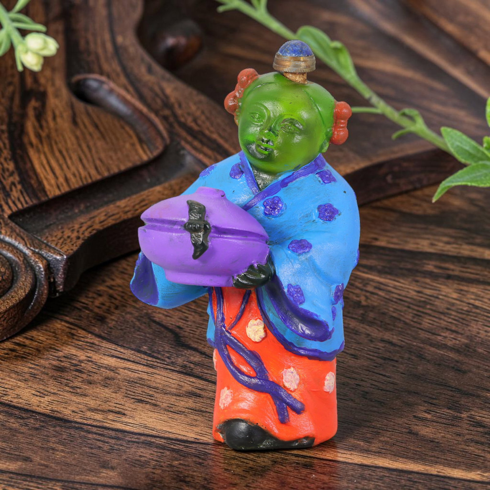 Vintage Chinese Liuli Glass Snuff Bottle - Child Holding Vessel, 33AS: This snuff bottle is moulded from translucent green liuli glass, formed as a standing child figure holding a covered vessel adorned with a bat motif. The robe features hand-painted enamel floral decor