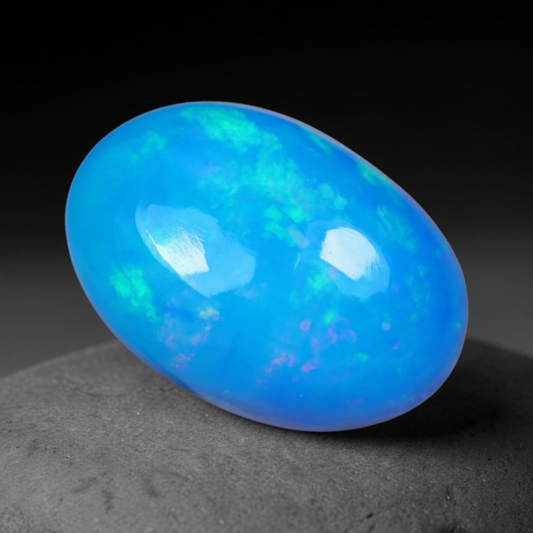 2.66 Carats Natural Ethiopian Welo Bright Sky Blue Opal Cabochon Loose Gemstone, 50AG: This smooth polished opal features a vivid saturated sky blue base scattered with soft mint green and faint lavender rolling play of color, measured at 12.8x8.8x5.5mm, its cool uniform blue palette cr