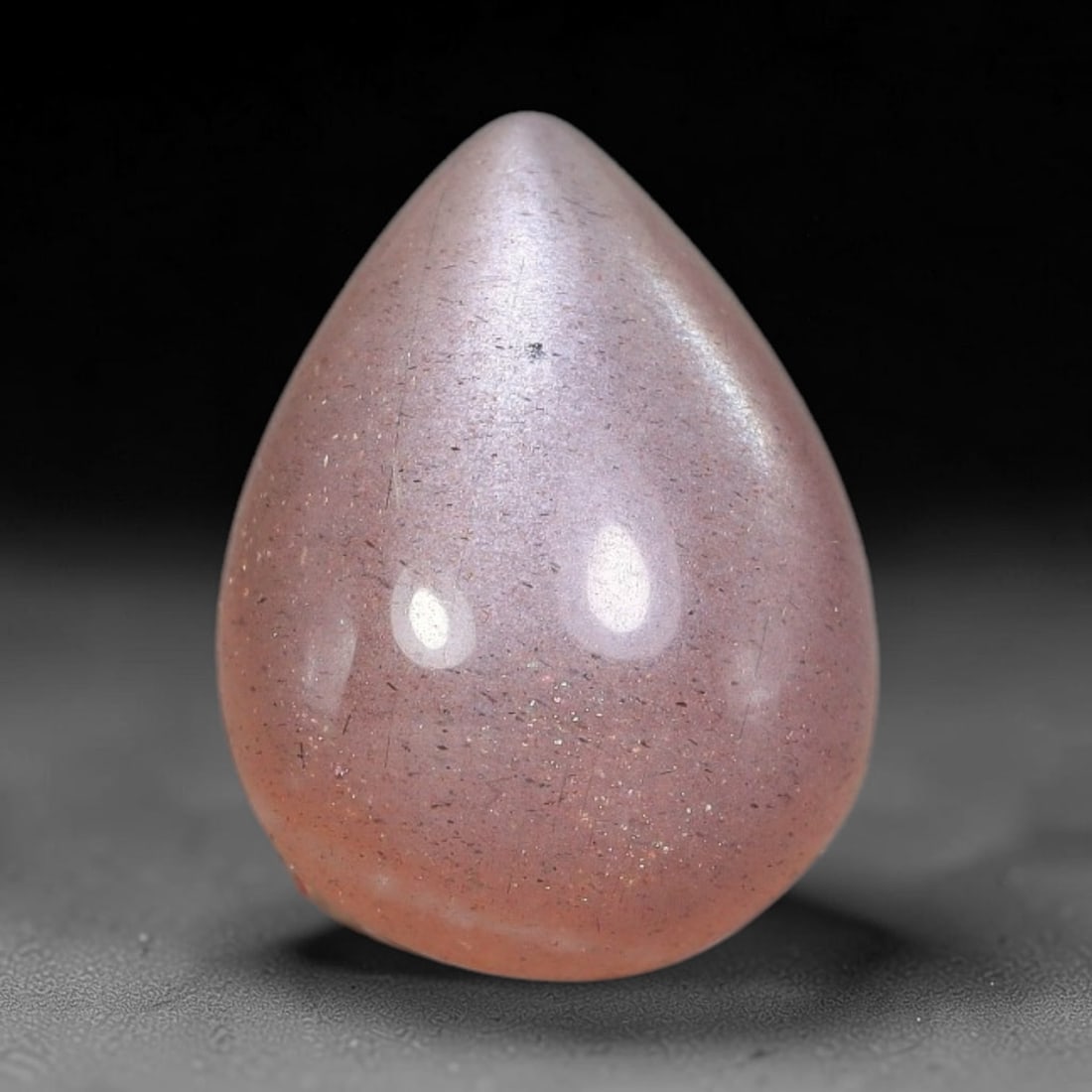 6.05 Carats Natural Ceylon Soft Peach Pink Moonstone Cabochon Loose Gemstone, 10AG: This warm soft peach pink moonstone features delicate sparkling mineral flecks scattered throughout its smooth surface paired with faint flowing adularescent glow, measured at 14.1x10.7x5.8mm, its gen