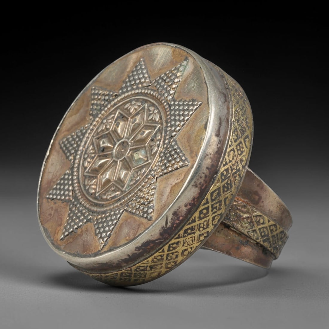 Antique Central Asian Mixed Metal Star Floral Signet Ring, 72AA: Vintage handcrafted Central Asian statement signet ring with a 3.2cm x 3.2cm circular ring face, constructed from silvered base metal with fine gilded inlaid decorative detailing across the band and d