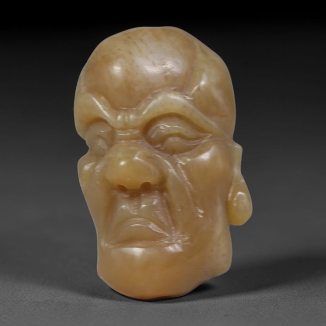 Natural Vintage Chinese Nephrite Jade Honey Brown Arhat Head Carved Face Bead, 31AP: Hand-carved vintage Chinese strung bead crafted from natural vintage Chinese nephrite jade, measuring 3cm x 1.8cm. This barrel-shaped bead is intricately sculpted as a solemn Buddhist Arhat head, feat