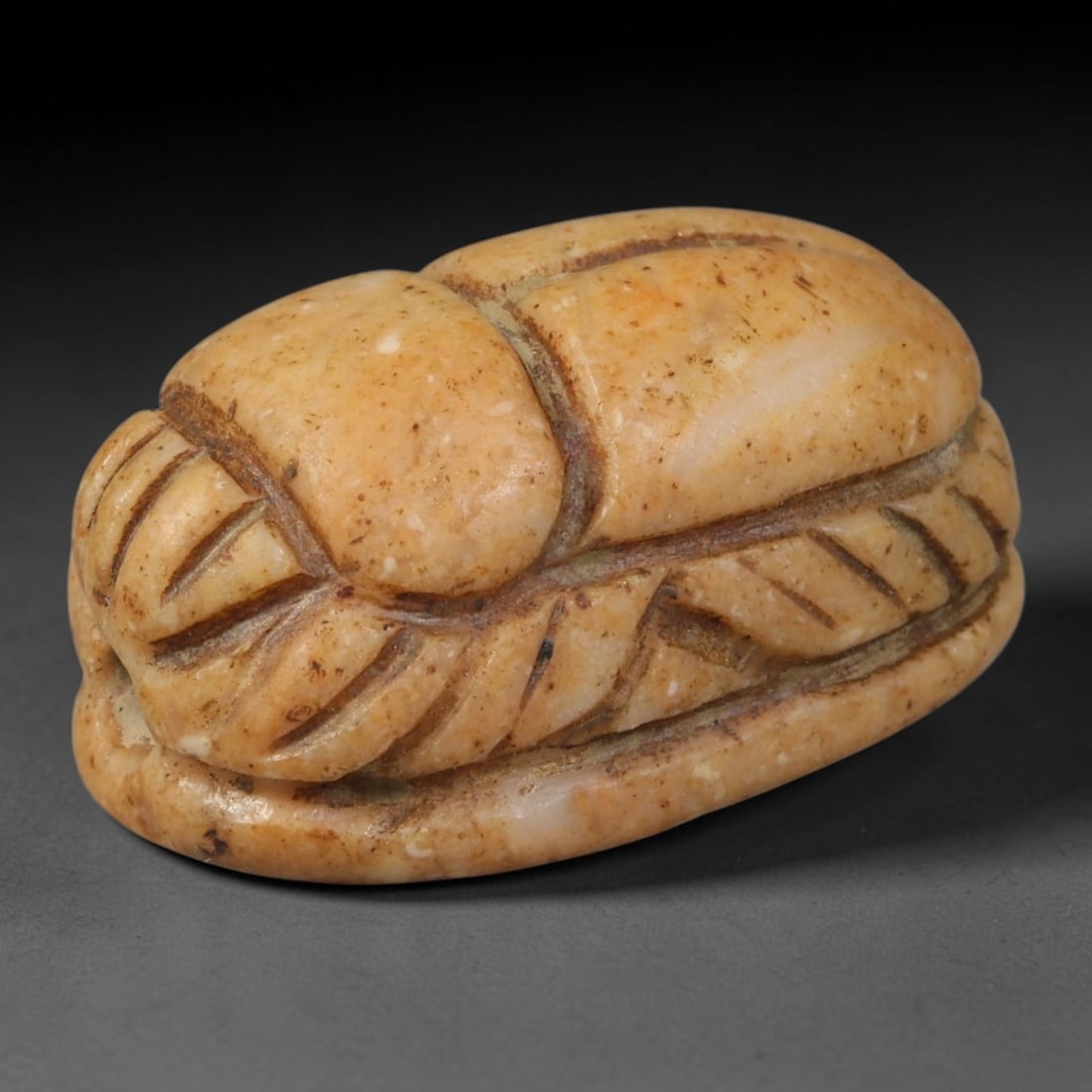 Ancient Egyptian Late Period Serpentine Scarab Amulet (664-30 BCE), 63AB: This pale peach serpentine scarab originates from Ancient Egyptian Late Period, revered funerary amulets symbolizing rebirth, protection and divine favor for the afterlife. Clean incised lines define 