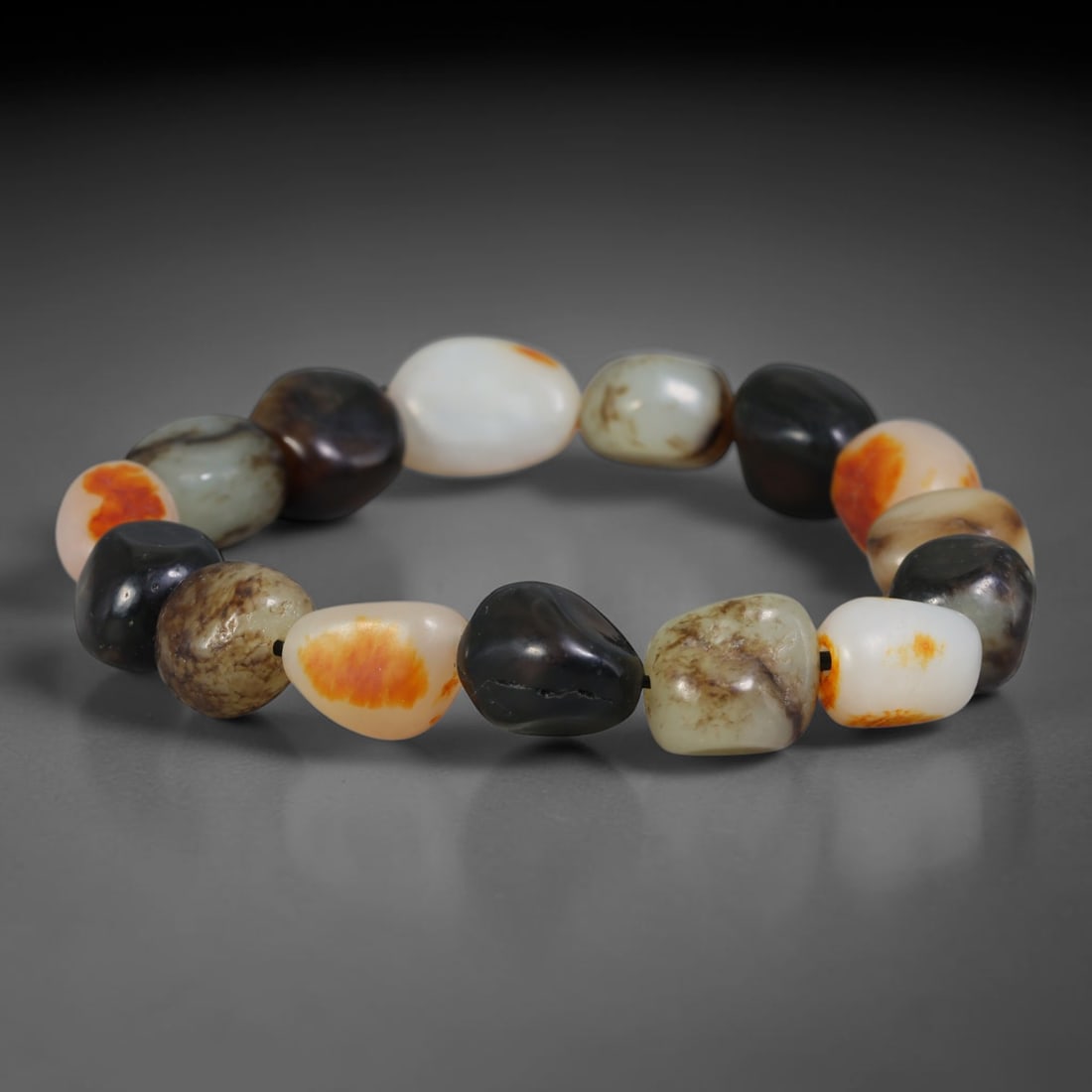 Natural Chinese Xinjiang Hetian Nephrite Jade Pebble Bracelet, 76AE: Composed of polished natural river pebble Hetian nephrite jade beads sourced from Xinjiang, each bead retains organic freeform shaping with varied natural skin tones including creamy white, deep black