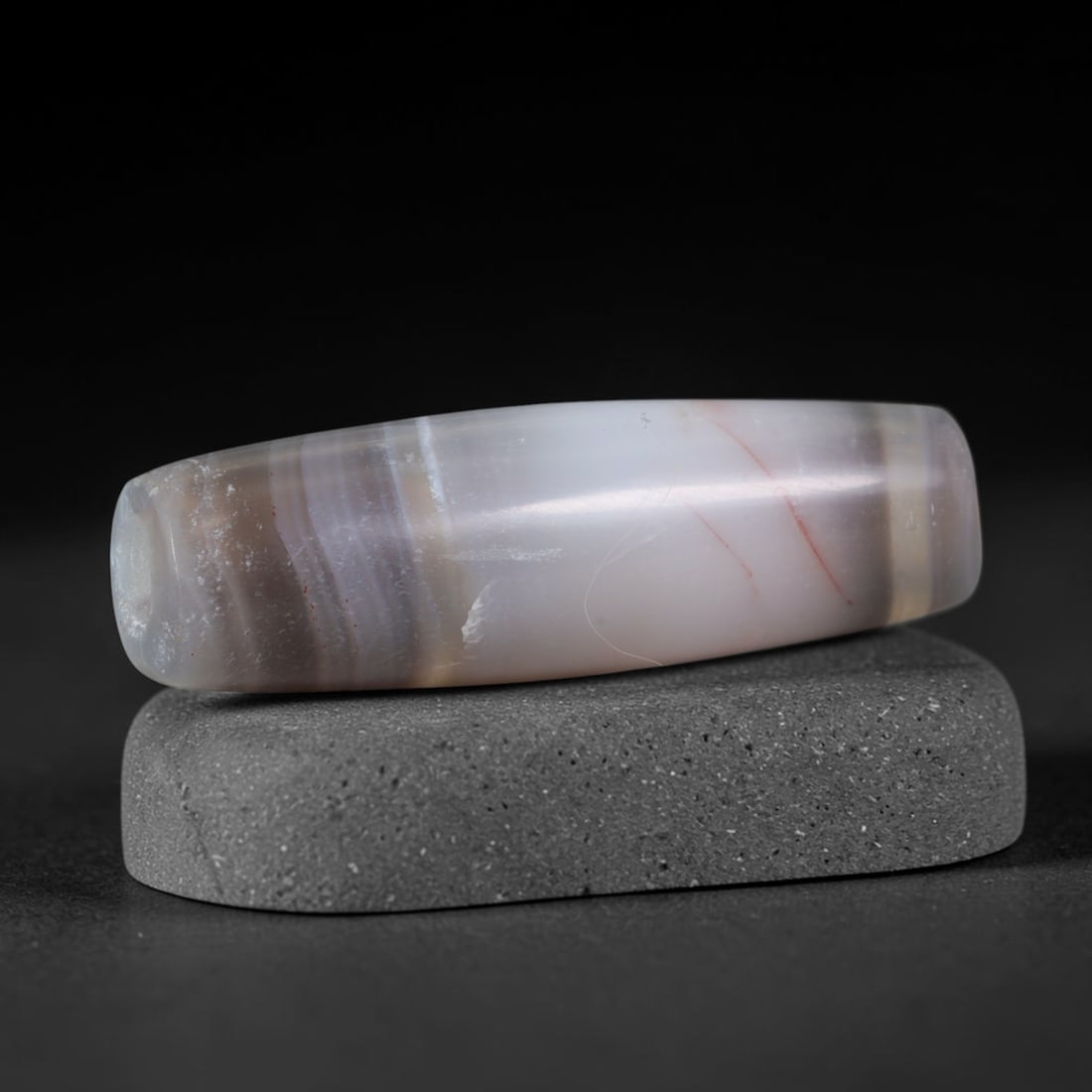 Ancient Sasanian Persian Empire Long Banded Agate Barrel Bead (224-651 CE), 85AD: This antique elongated banded agate barrel bead originates from the Sasanian Persian Empire, the last pre-Islamic Persian civilization celebrated for master agate carving traditions that produced prot