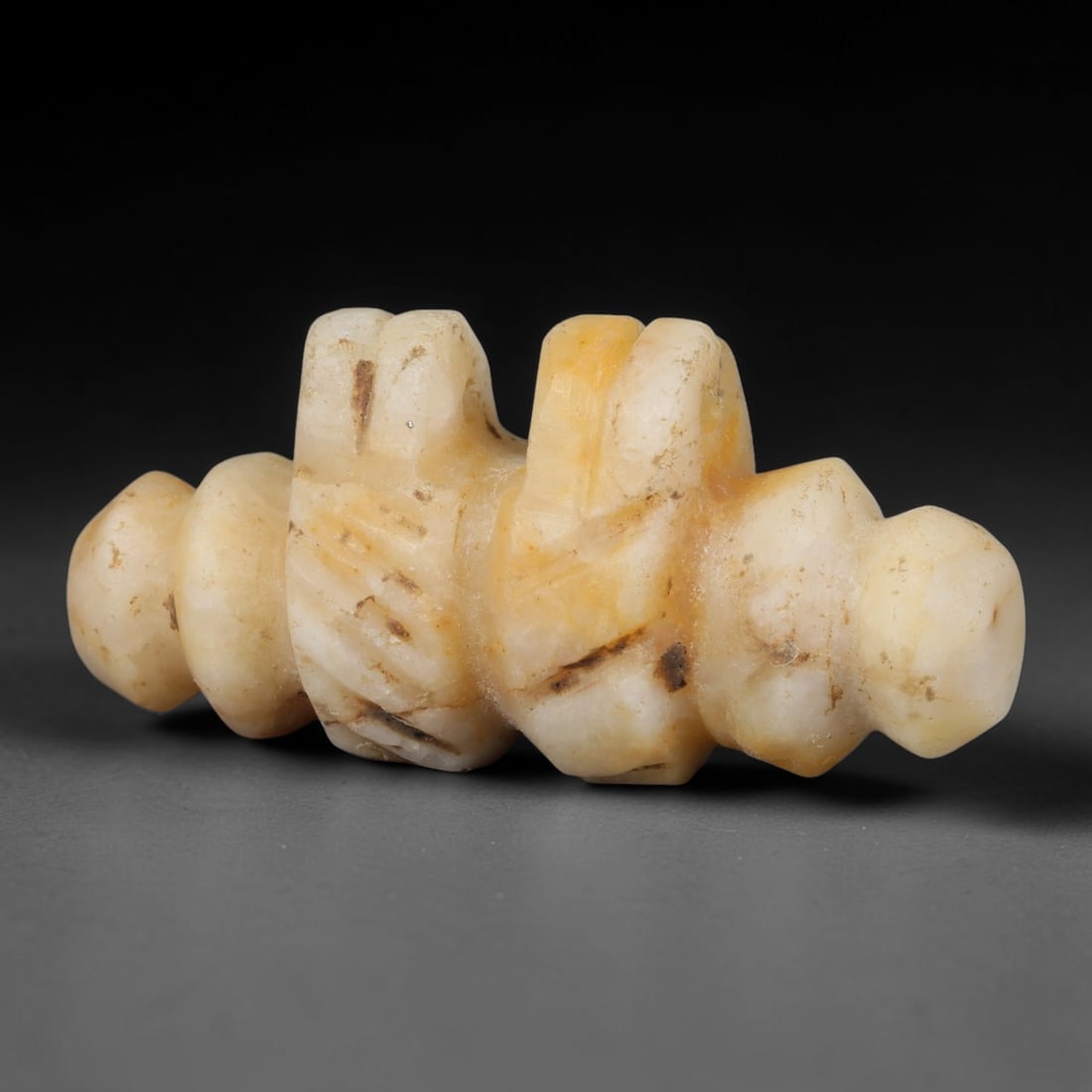 Ancient Egyptian Pale Calcite Djed Pillar Amulet (664-30 BCE), 47AB: Hand-carved symmetrical Djed pillar talisman from pale creamy calcite with natural amber veining and dark mineral inclusions. Detailed segmented ribbed carvings replicate the symbolic backbone of Osir