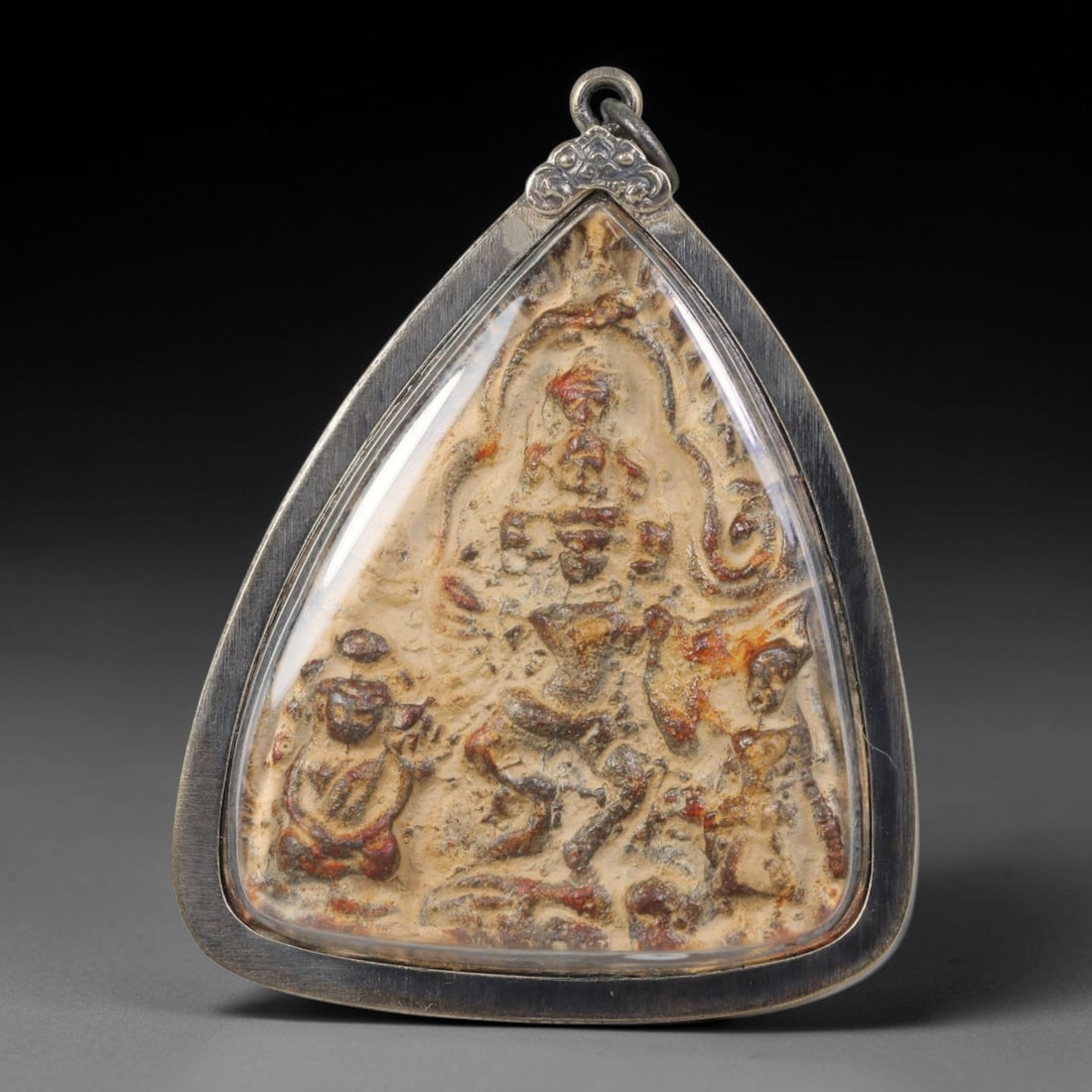 Vintage Thai Amulet Pendant - Triangular Clay Buddha Talisman with Aluminium Casing, 94AA: Authentic vintage Thai triangular clay amulet measuring 6.5x5 cm, molded with embossed central deity figure flanked by attendant small sacred statues, finished with faded aged red pigment against natu