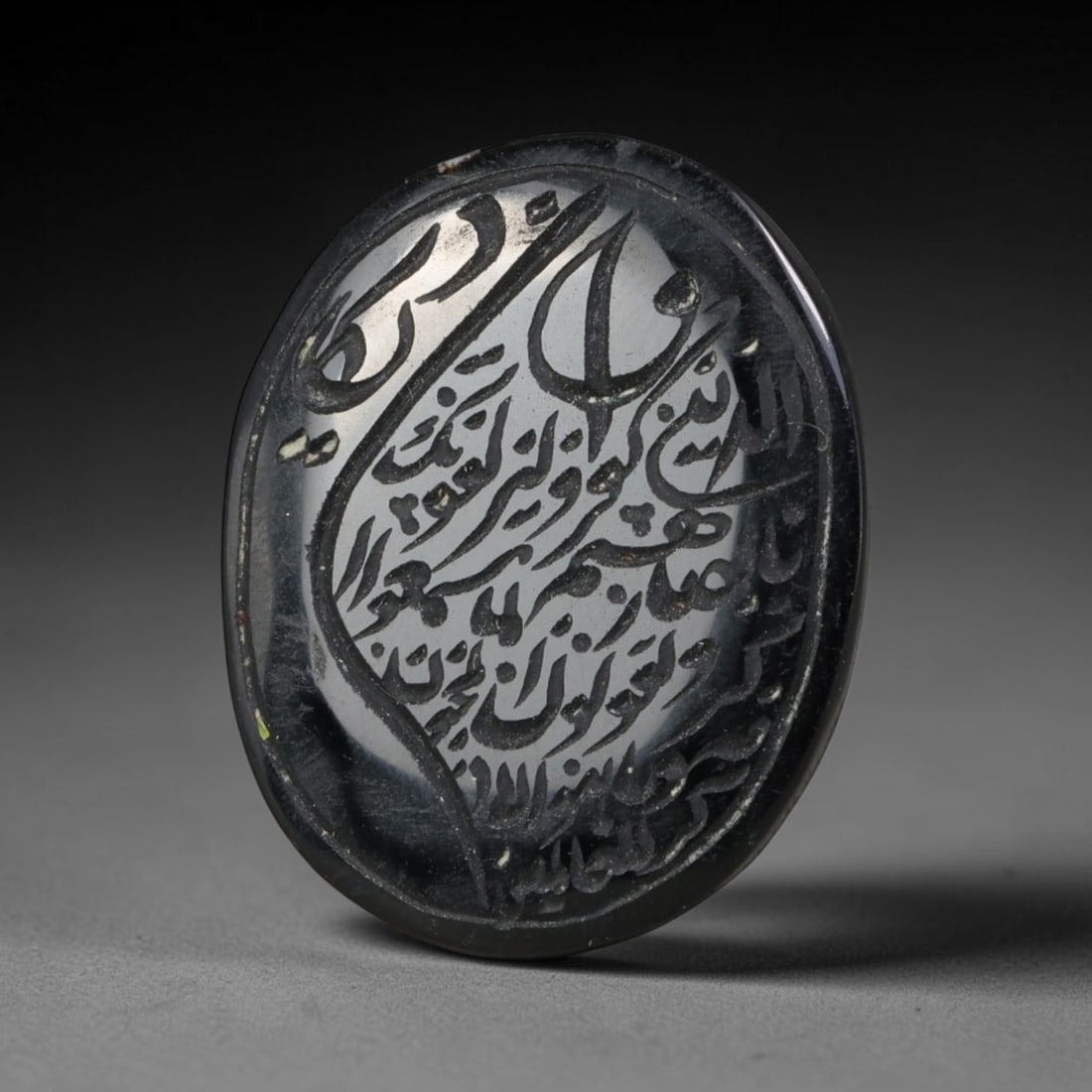 Islamic Intaglio Script Tablet Black Hardstone Oval Seal, 36AE: Formed from polished dark black hardstone with faint minor surface flecks, this oval tablet features deeply incised intaglio Islamic calligraphic script covering its face, rendered in fluid cursive le