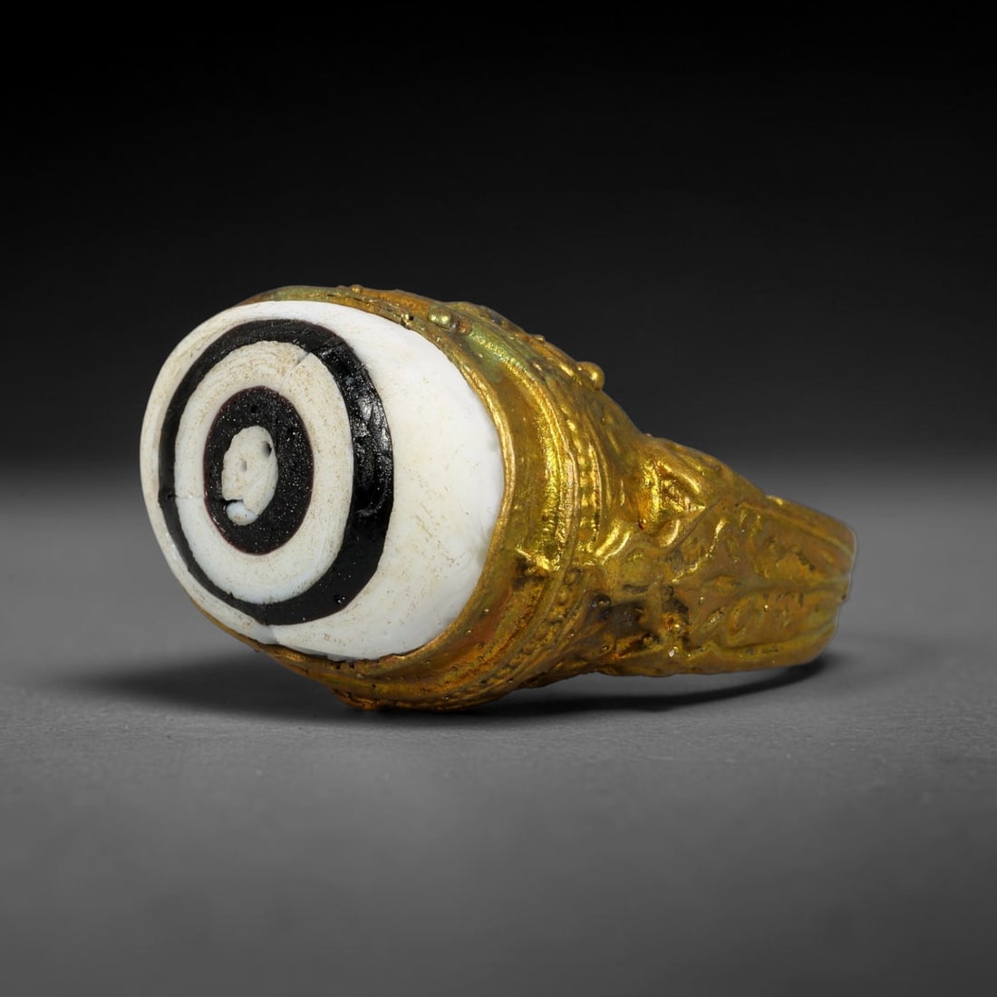 Antique Qajar Dynasty Copper Alloy Ring Set With Banded Glass Bead Cabochon, 62AC: Historic wearable signet ring crafted from textured copper alloy metal, sized to US ring size 7.50, originating from Qajar Persian artistic and adornment traditions of late medieval Iran. Copper alloy