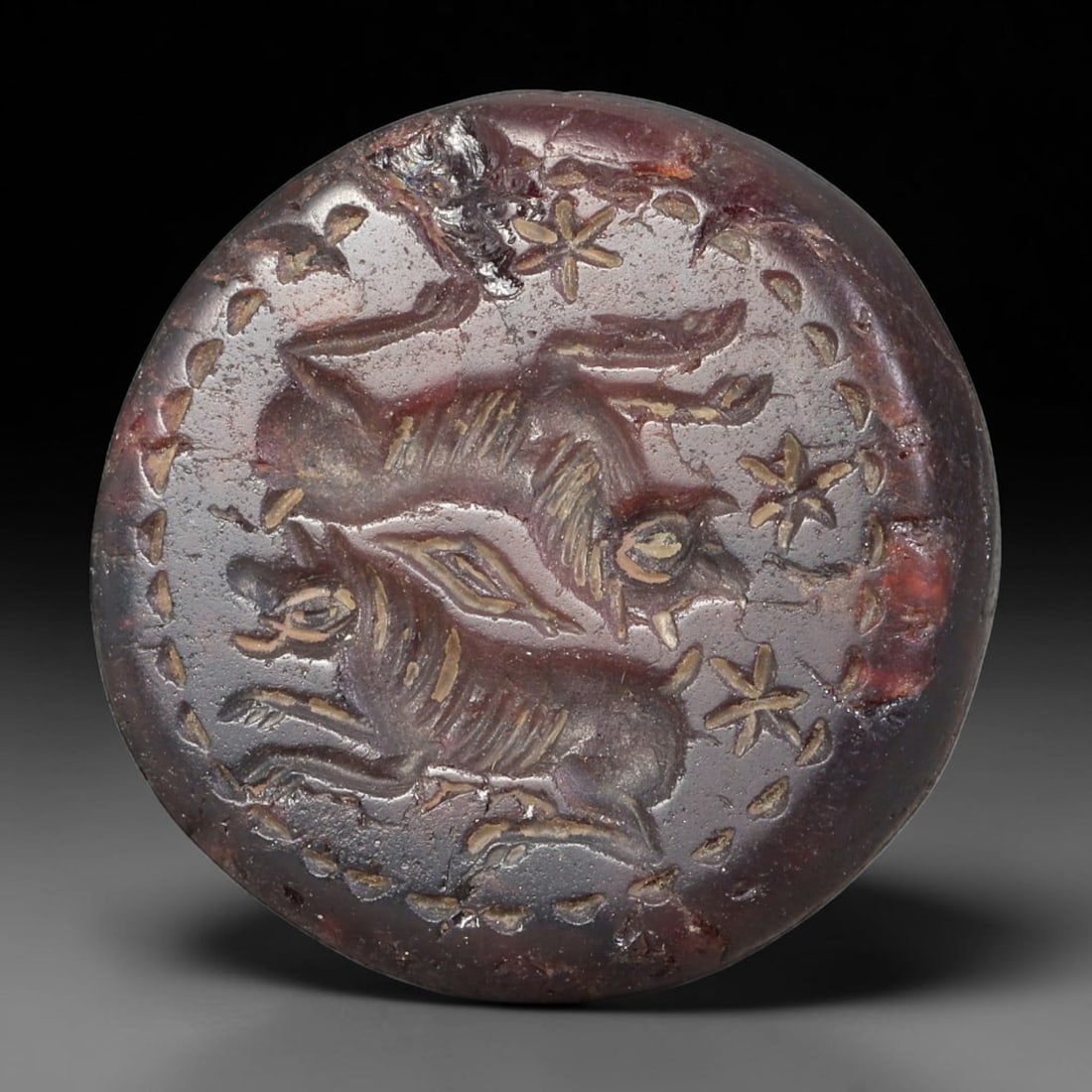 Ancient Sasanian Natural Garnet Dome Seal Bead (224-651 CE), 72AB: Domed oval bead seal carved from deep red natural garnet, fully pierced horizontally for suspension as a wearable stamp talisman. The flat circular face features fine intaglio engraving of two opposin