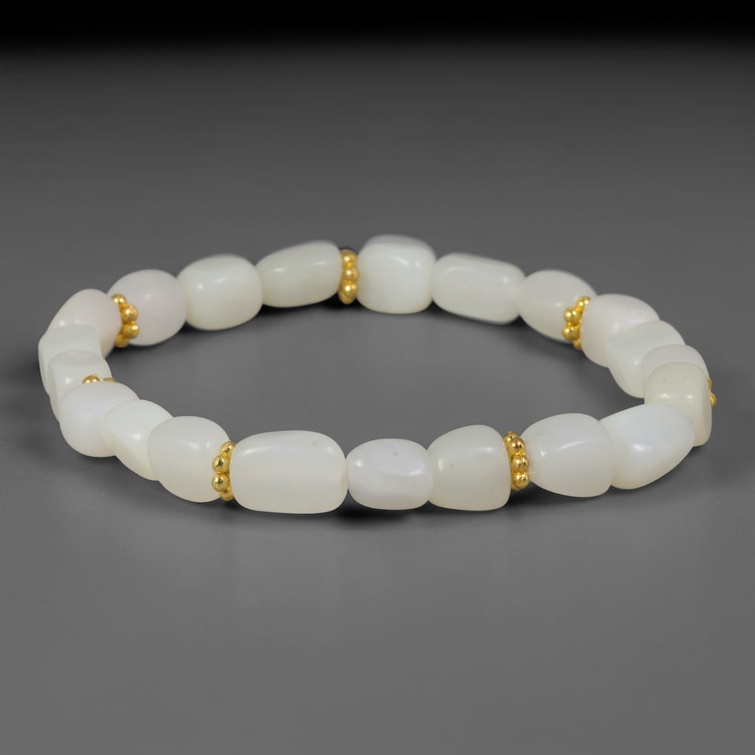 Natural Chinese Xinjiang Hetian Nephrite Pure White Pebble Bracelet, 78AE: Minimalist hand-strung bracelet crafted from polished natural Xinjiang Hetian nephrite river pebble beads in soft organic freeform shapes, separated by tiny textured gold-toned metallic spacer beads. 