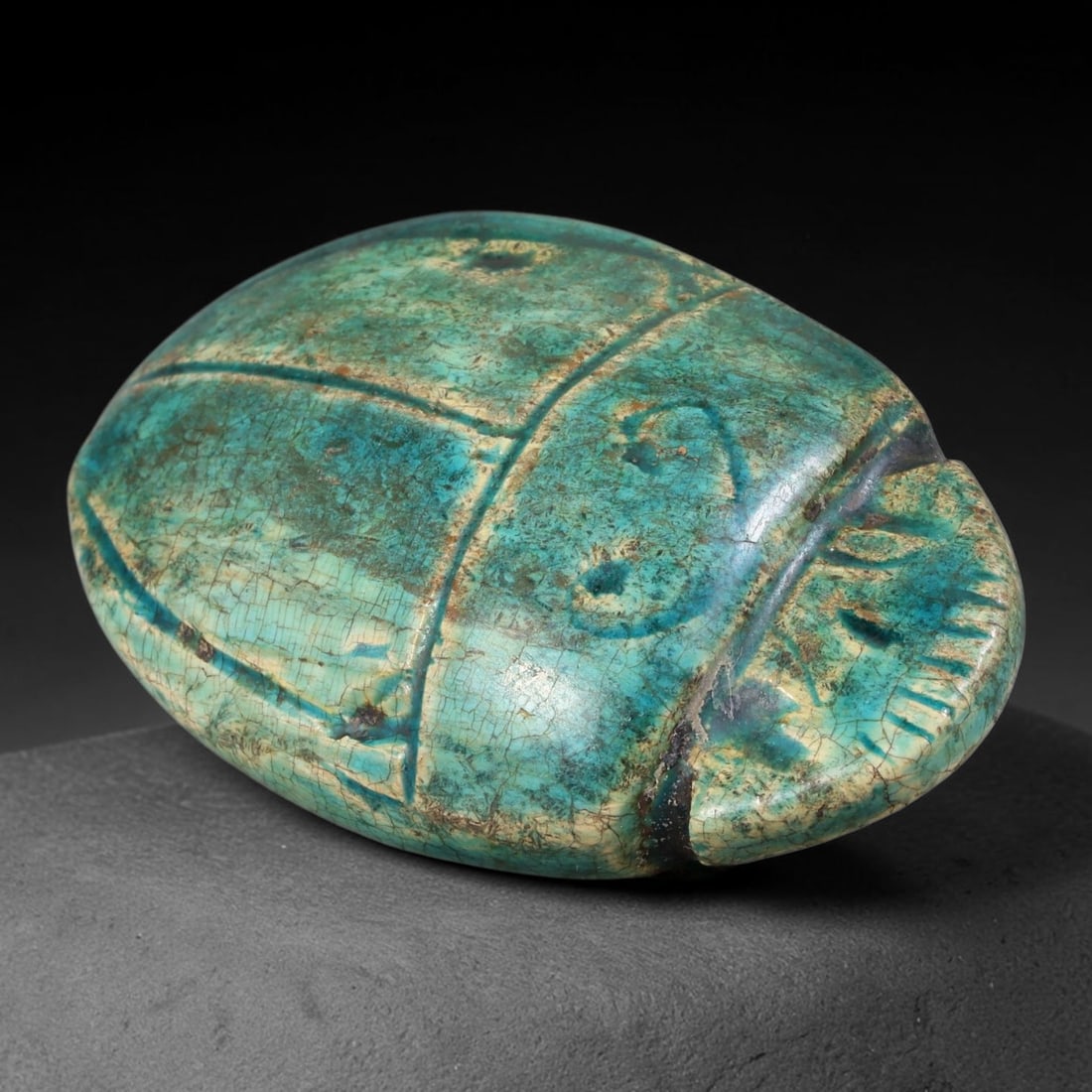 Ancient Egyptian Late Period Turquoise Faience Scarab Amulet (664-30 BCE), 65AB: Large molded Egyptian faience scarab funerary talisman glazed in rich turquoise blue, exhibiting extensive antique craquelure across the entire glazed surface with significant glaze wear revealing pal