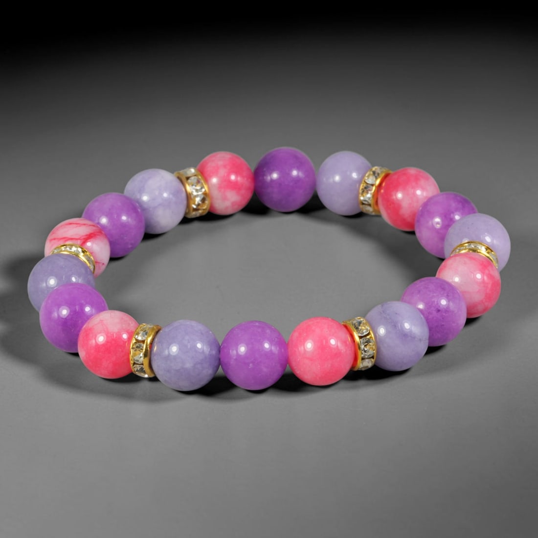 Natural Mixed Stone Beaded Bracelet - Polished Round Bead Strand, 46FA: This elastic stretch bracelet is formed from uniformly spherical polished natural mineral beads paired with gold-toned metal spacers set with clear crystalline accents. The stone material shows rich p