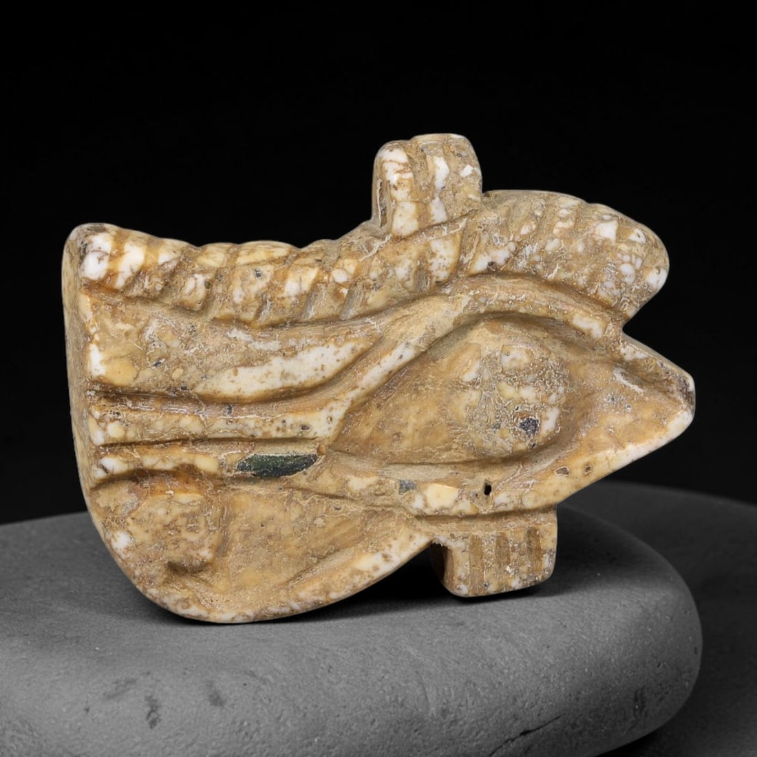 Ancient Egyptian Wedjat Eye Stone Protective Amulet (664-30 BCE), 87AE: Hand-carved mottled cream-brown fossil stone amulet shaped as the sacred Wedjat Eye of Horus, a core ancient Egyptian talisman symbolizing healing, protection, divine sight and warding off evil. Detai