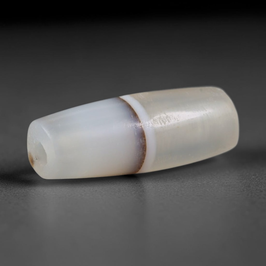 Ancient Mehrgarh Culture Banded Agate Barrel Bead (7000-2600 BCE), 11AD: This antique banded agate barrel bead originates from the Mehrgarh Culture, the world's earliest confirmed agate bead workshop civilization featuring primitive pecked and drilled chalcedony craft pred