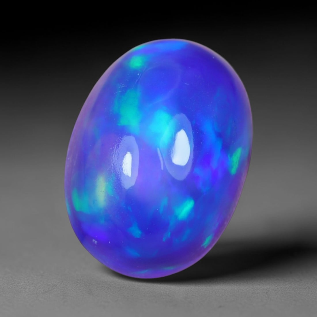2.62 Carats Natural Ethiopian Welo Violet Blue Opal Cabochon Loose Gemstone, 56AG: This striking opal carries a saturated deep violet and electric blue iridescent glow across its smooth polished dome, measured at 13.4x9.6x6.1mm, the uniform rich cool-toned flash delivers bold eye-ca