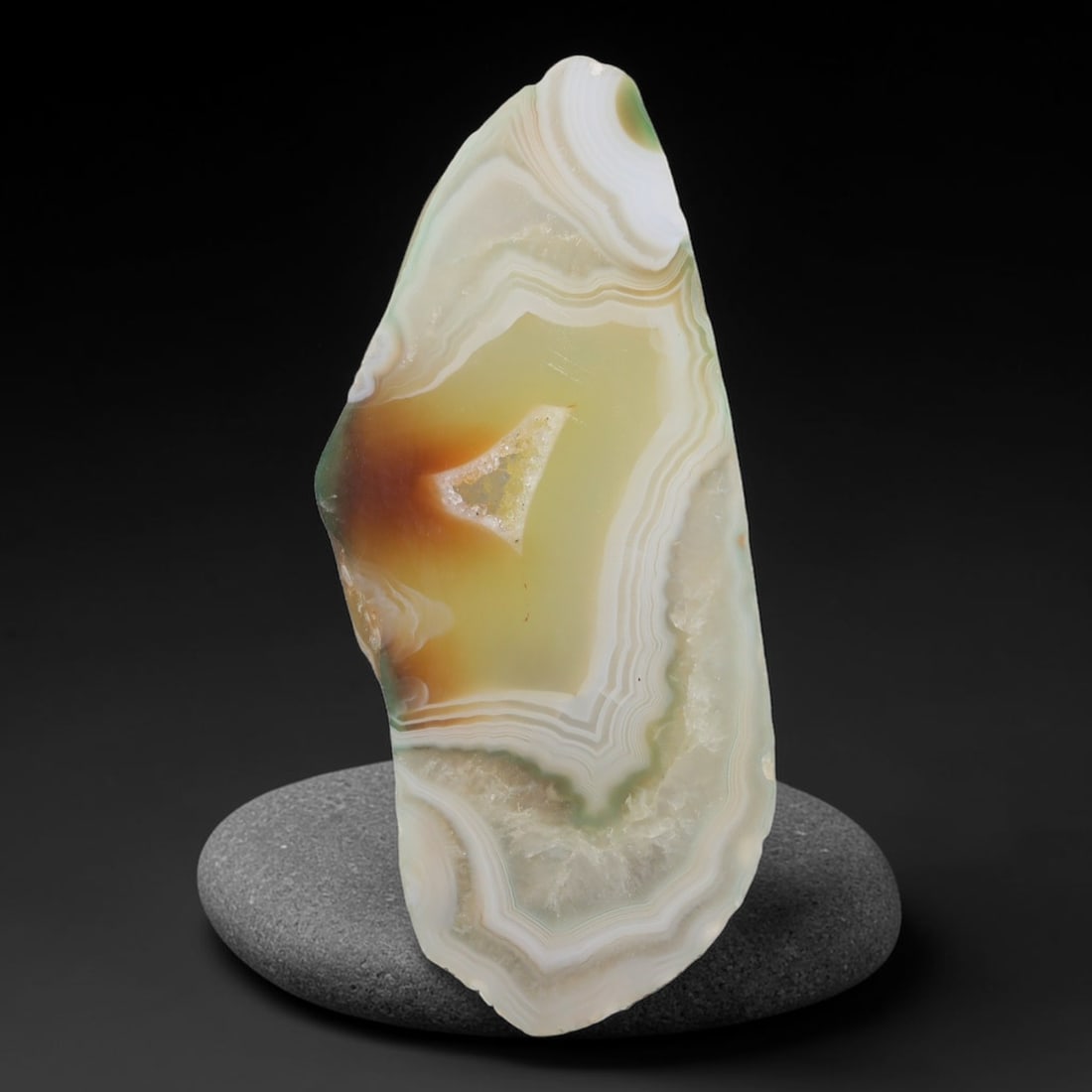 Natural Gobi Desert Banded Agate Slice with Central Druzy Pocket, 65AA: Polished natural Gobi desert agate slab measuring 6.2cm x 2.7cm, featuring delicate concentric layered banding in creamy white, soft sage green, honey amber and pale yellow tones. A distinct triangula