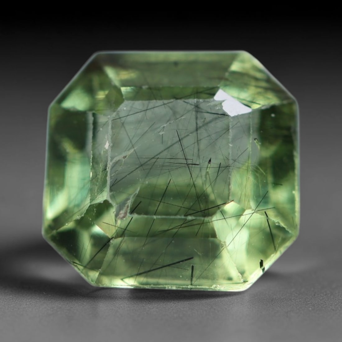 3.19 Carats Natural Pakistani Olive Green Rutilated Peridot Loose Gemstone, 86AH: This translucent peridot displays soft olive green base tone intersected by prominent thin dark needle-like rutile inclusions that create striking linear internal patterns, measured at 8.7x8.5x5.2mm. 