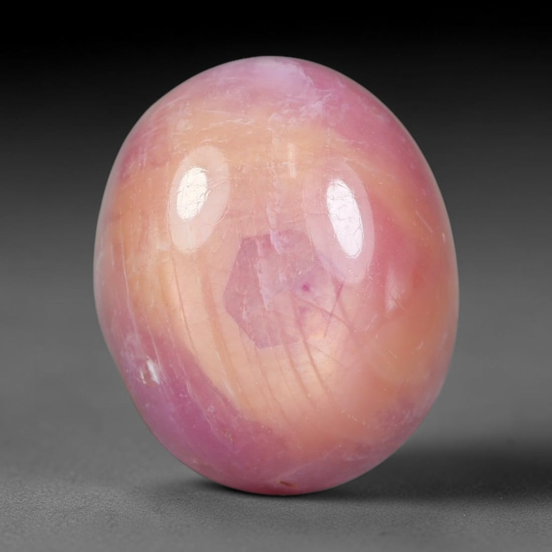 13.56 Carats Natural Madagascar Soft Rose Pink Heated Ruby Cabochon Loose Gemstone, 95AH: This warm blush-toned ruby cabochon carries blended swathes of soft rose pink and gentle peach undertones, with faint natural mineral veining throughout the polished dome, measured at 13.6x11.2x7.6mm.
