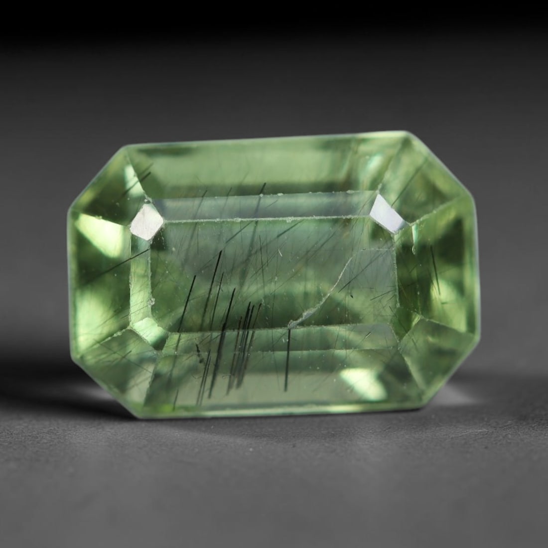 3.27 Carats Natural Pakistani Olive Green Rutilated Peridot Loose Gemstone, 87AH: This translucent peridot displays soft olive green base tone intersected by prominent thin dark needle-like rutile inclusions that create striking linear internal patterns, measured at 10.3x6.8x5.5mm.