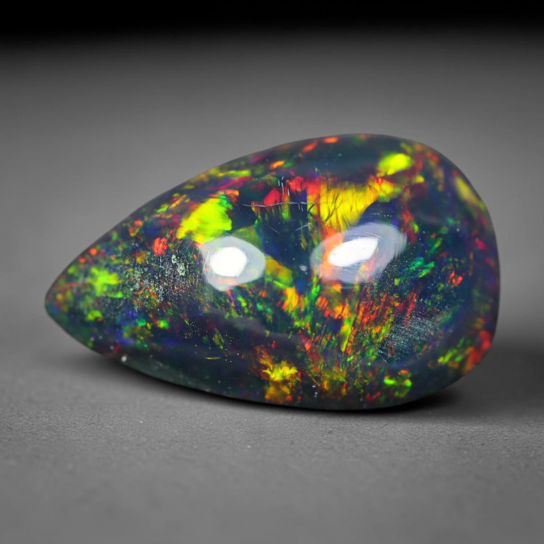 2.13ct Natural Ethiopian Welo Black Smoked Opal Cabochon Loose Gemstone, 81AK: This fully polished Ethiopian Welo opal features a dark smoked base with vivid, sweeping play-of-color shifting across its glossy dome surface, measured at 12.4x7.6x5mm. The black smoke treatment deep